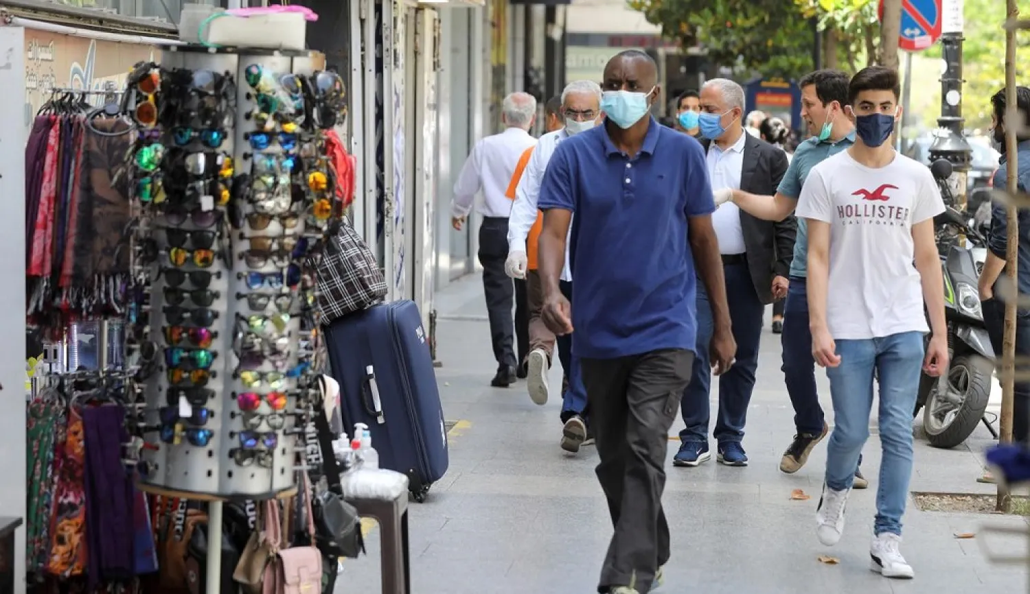 People wearing protective face masks walk past open shops in Hamra street in Beirut, Lebanon May 18, 2020. (Reuters)