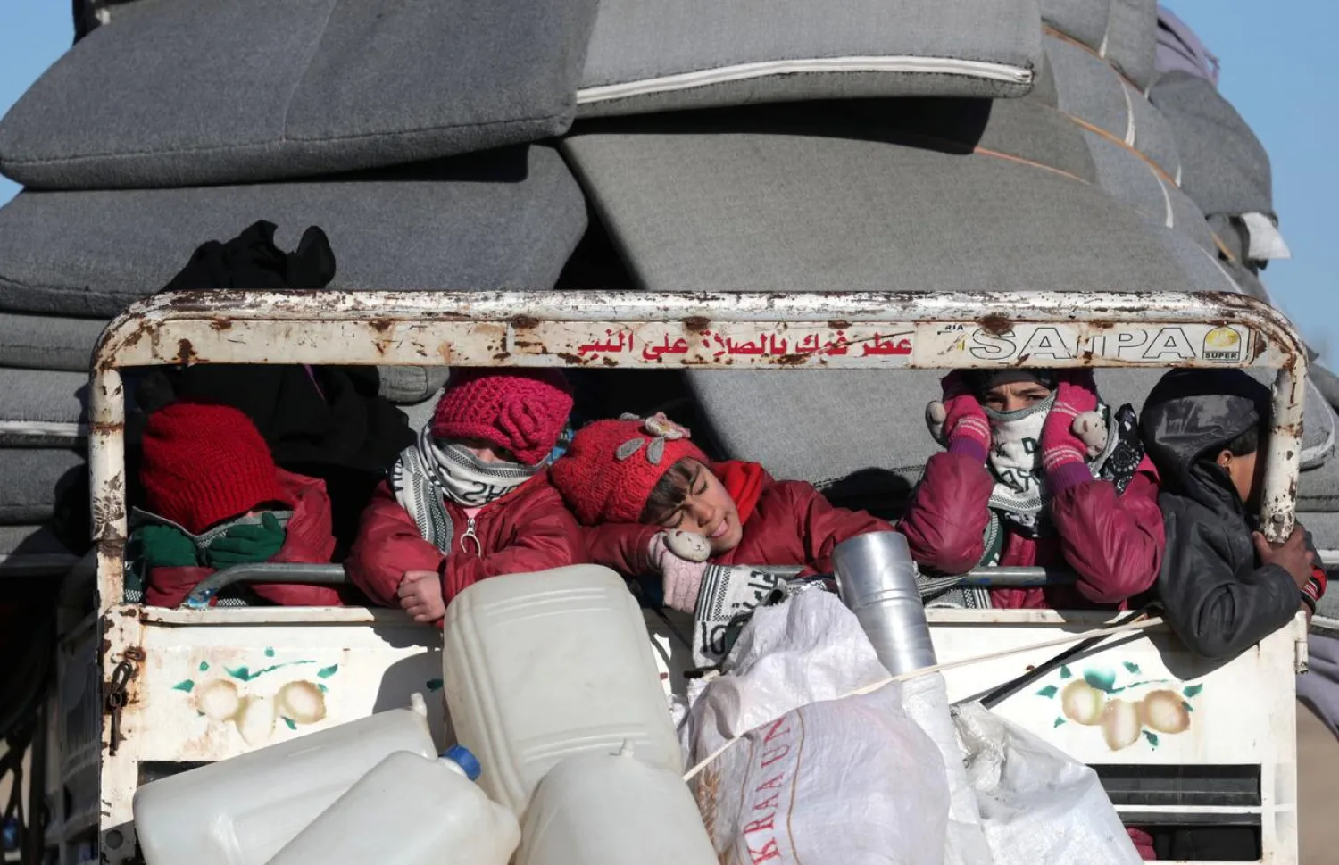 Displaced Syrian children ride with belongings at a back of a truck, in Azaz, Syria January 24, 2020. Picture taken January 24, 2020. REUTERS/Khalil Ashawi