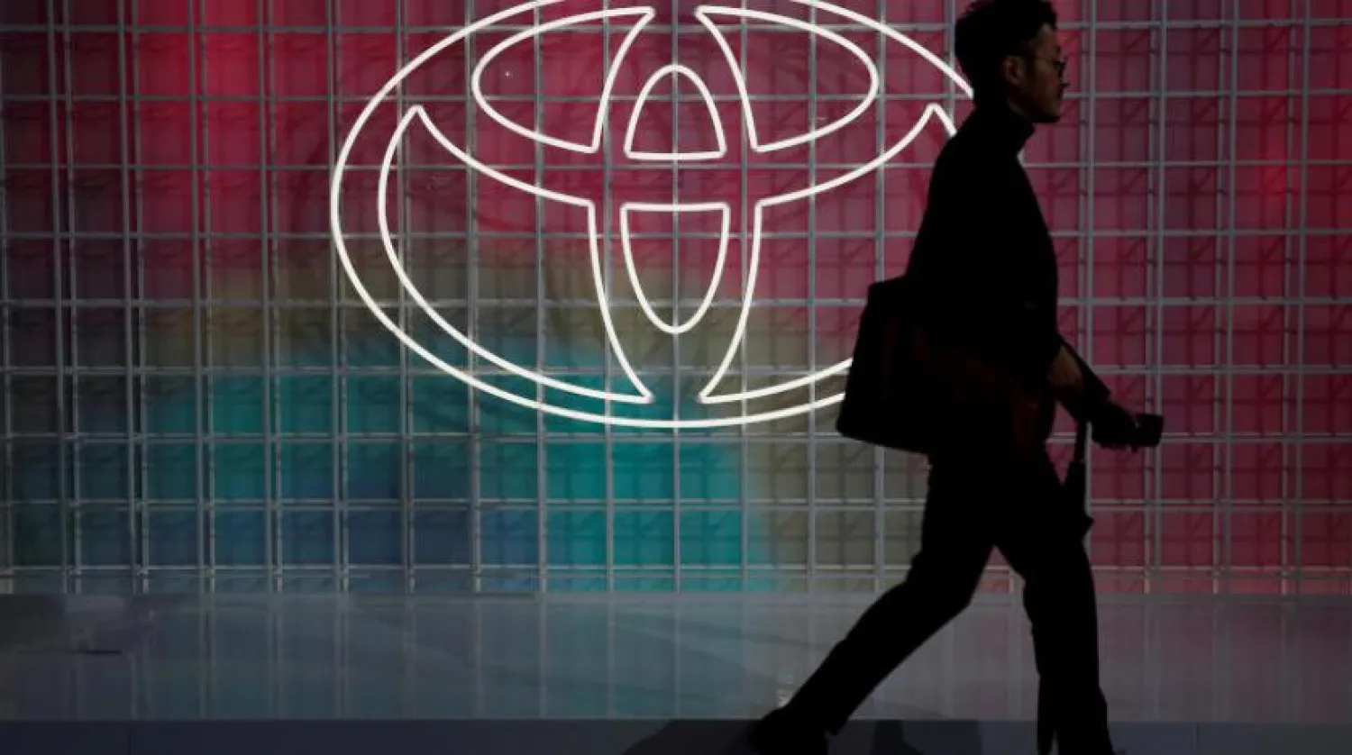 Tokyo'daki Japon Toyota logosunun önünden geçen bir adam (Reuters)