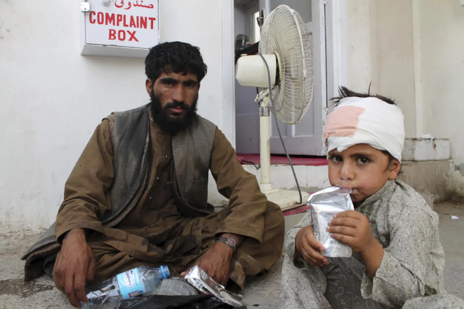 طفل أصيب بجروح في هجوم سابق على إحدى الأسواق يجلس على الأرض في مستشفى بإقليم هلمند (أ.ب)