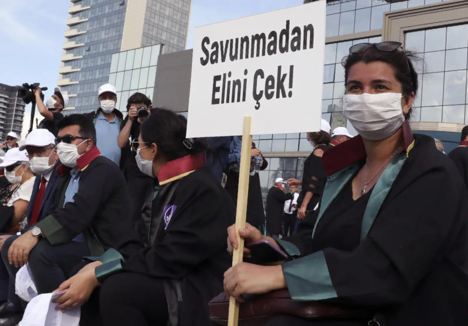 محامون في أنقرة يحملون لافتة كتب عليها «لا تمسّوا الدفاع» احتجاجاً على قانون مثير للجدل يرون أنه يضعف نقابتهم (أ.ب)