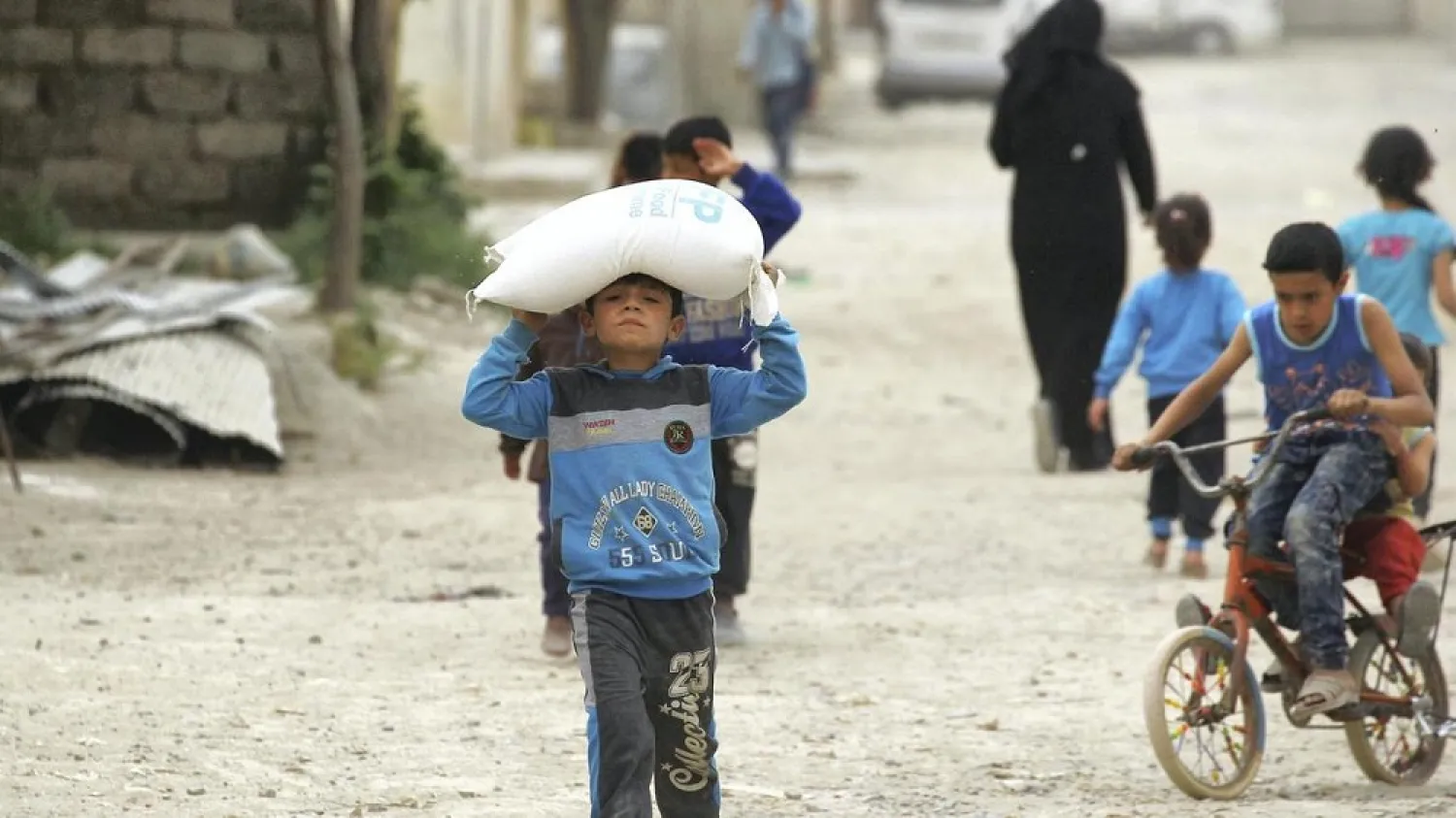 A boy carries food aid given by UN's World Food Program in Raqqa, Syria. (Reuters)