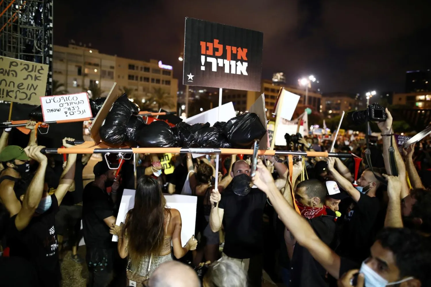 Israelis carry a stretcher as they protest against the government's response to the financial fallout of the coronavirus disease (COVID- 19) crisis at Rabin square in Tel Aviv, Israel July 11, 2020. REUTERS/Ammar Awad