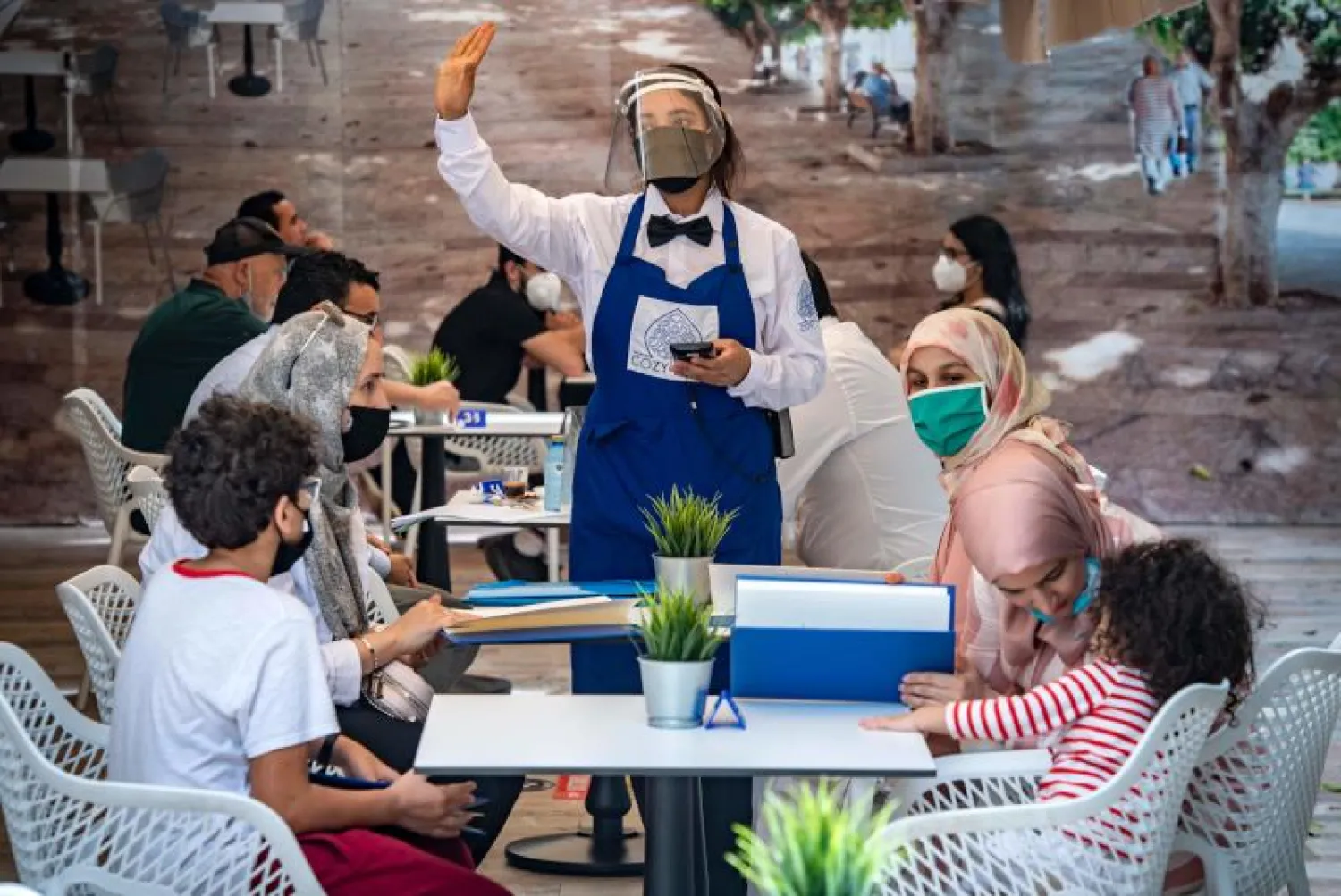 زبائن يرتدون أقنعة واقية بمقهى في العاصمة المغربية (أ.ف.ب)