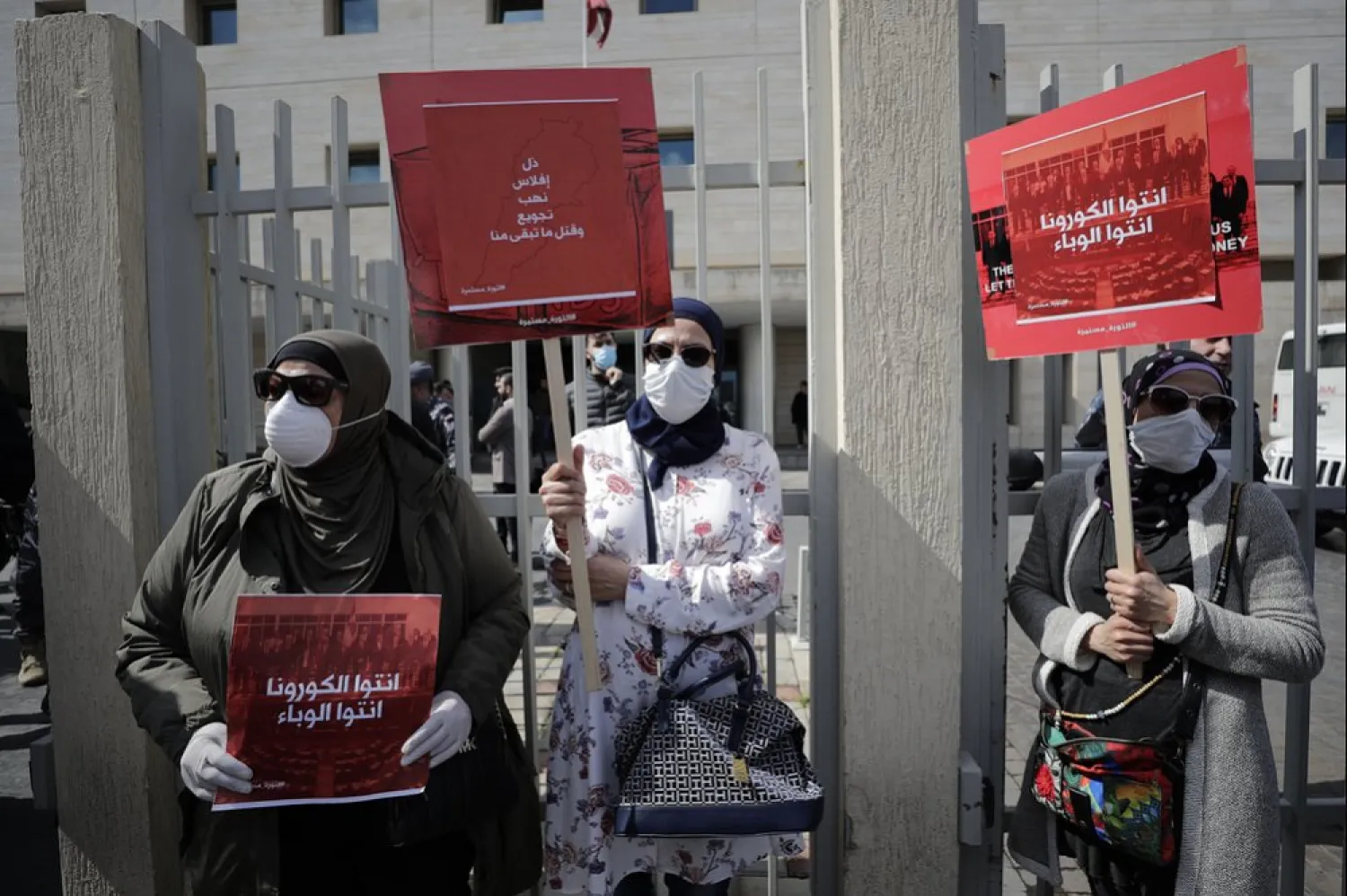 Anti-government protesters in Beirut hold banners reading 'You are the coronavirus, you are the epidemic,' and 'Humiliation, bankruptcy, looting, starving and killing the rest of us'. (AP)