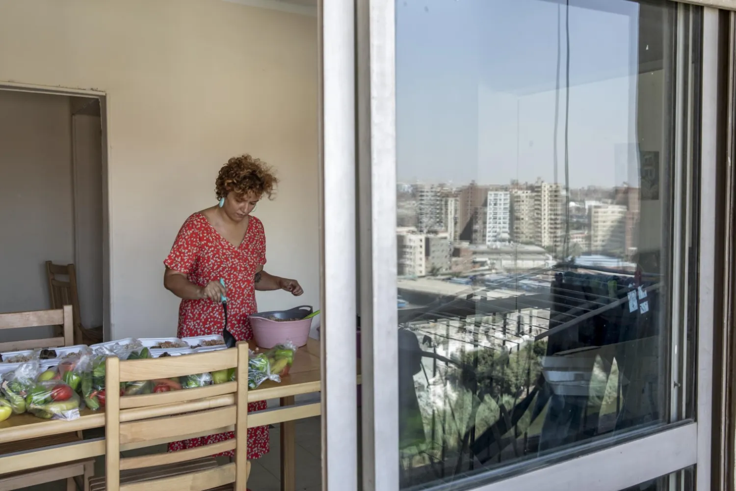Basma Mostafa, a 30-year-old journalist who founded an initiative that sends freshly home cooked meals to quarantined coronavirus patients, packages food at her friend's apartment, in Cairo, Egypt. Saturday, July 11, 2020. (AP Photo/Nariman El-Mofty)