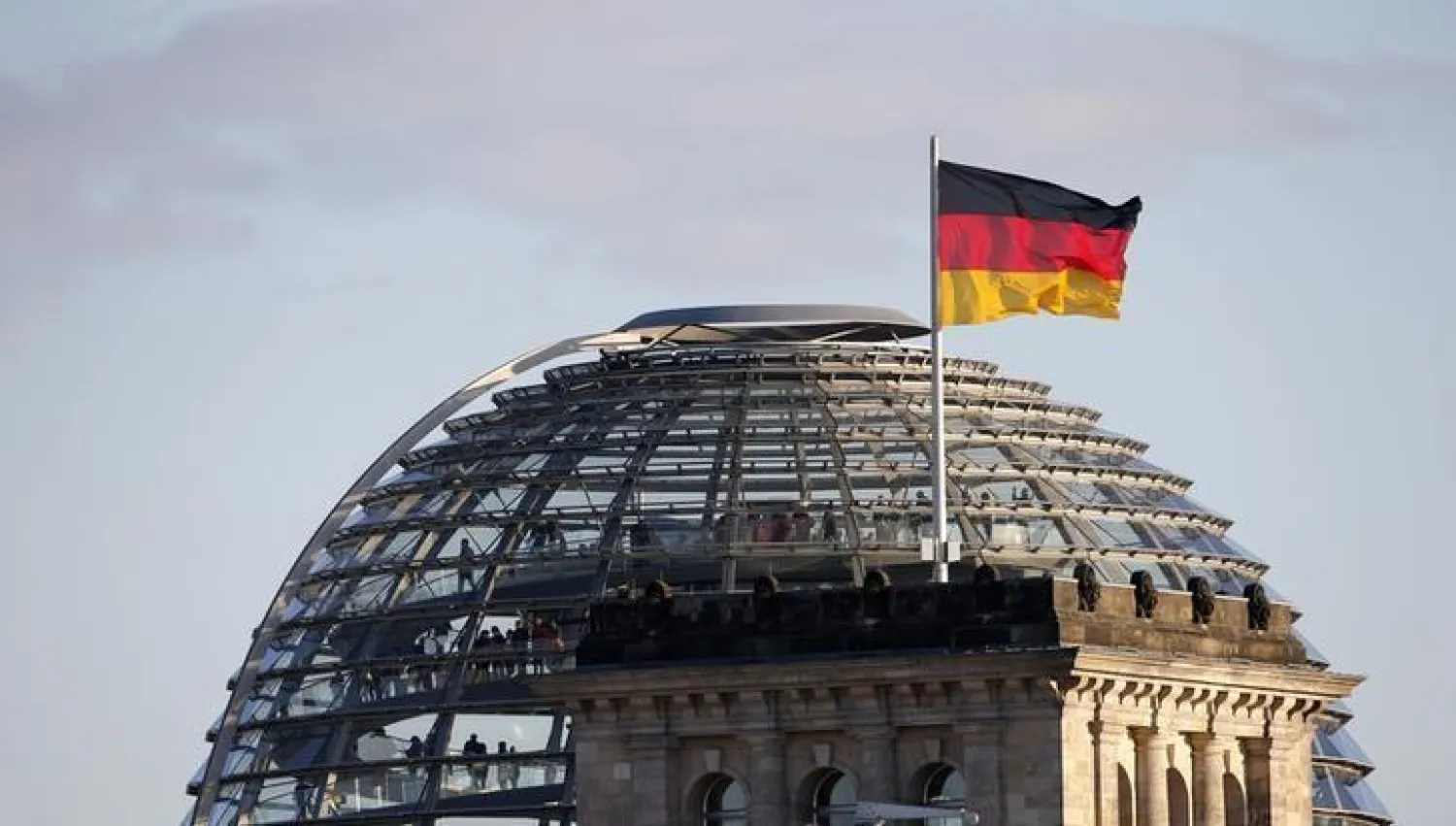 A German flag flutters next to the dome of the Reichstag building, seat of the German lower house of parliament Bundestag, in Berlin, October 2, 2013. REUTERS/Fabrizio Bensch