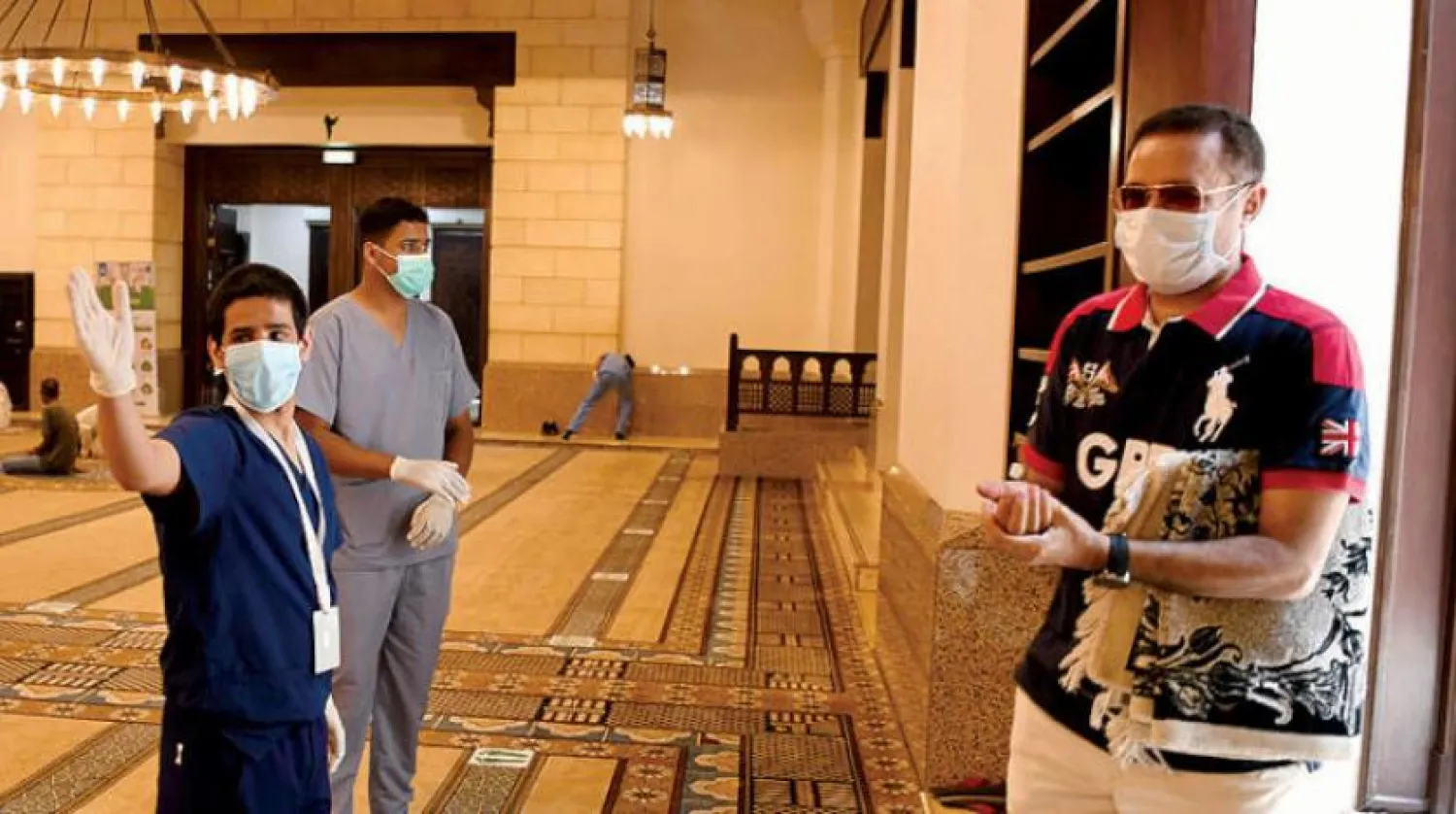 Volunteers enforce precautionary measures at a Saudi mosque. Photo by Bashir Salih