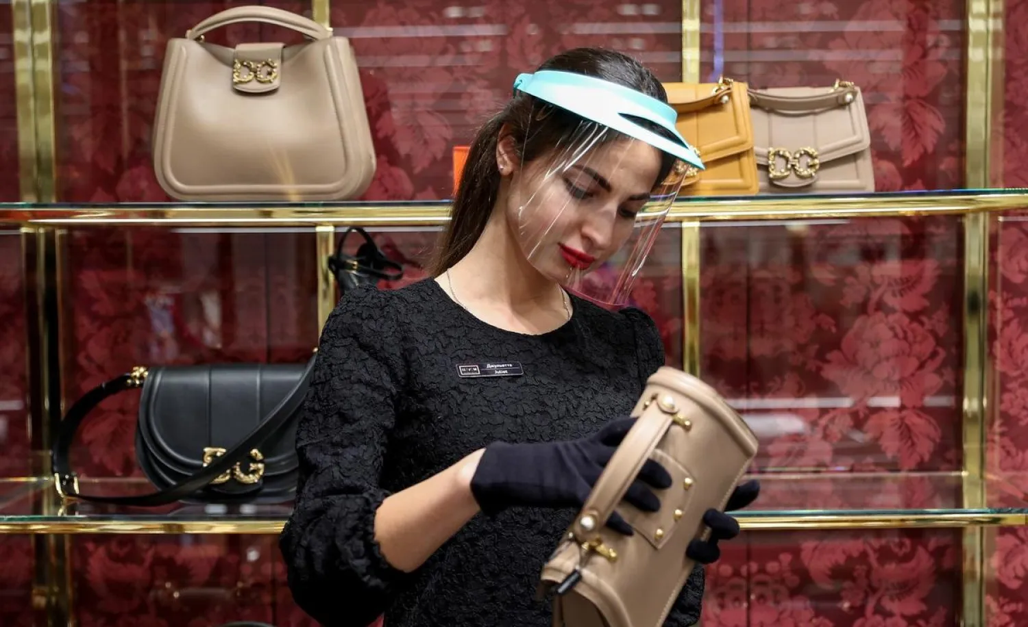 A shop assistant stands near a showcase with handbags produced by Dolce & Gabbana, in the TsUM Central Universal Department Store in central Moscow, Russia March 26, 2020. (Reuters)