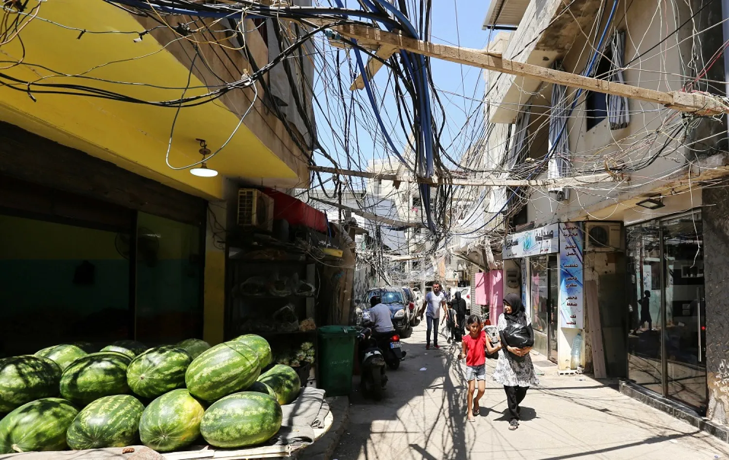 People walk along a street covered with electricity cables at Burj al-Barajneh refugee camp in Beirut. (Reuters)