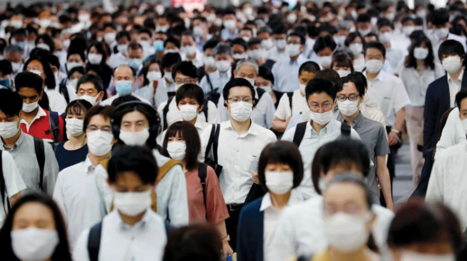 يابانيون يرتدون كمامات في محطة قطار بطوكيو يوم 3 يوليو (رويترز)