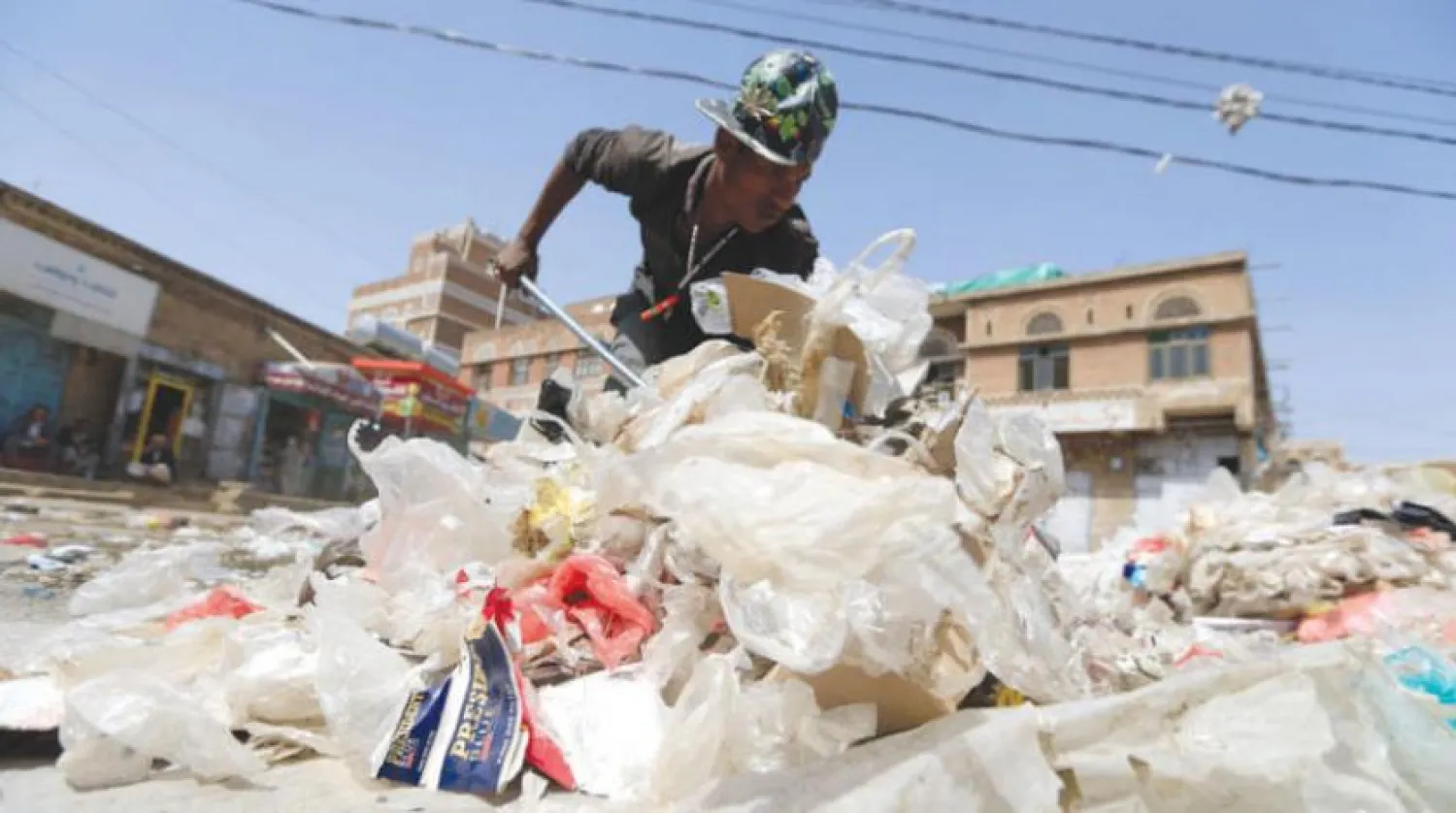 A Yemeni worker collects garbage from a street in Sanaa (AFP)