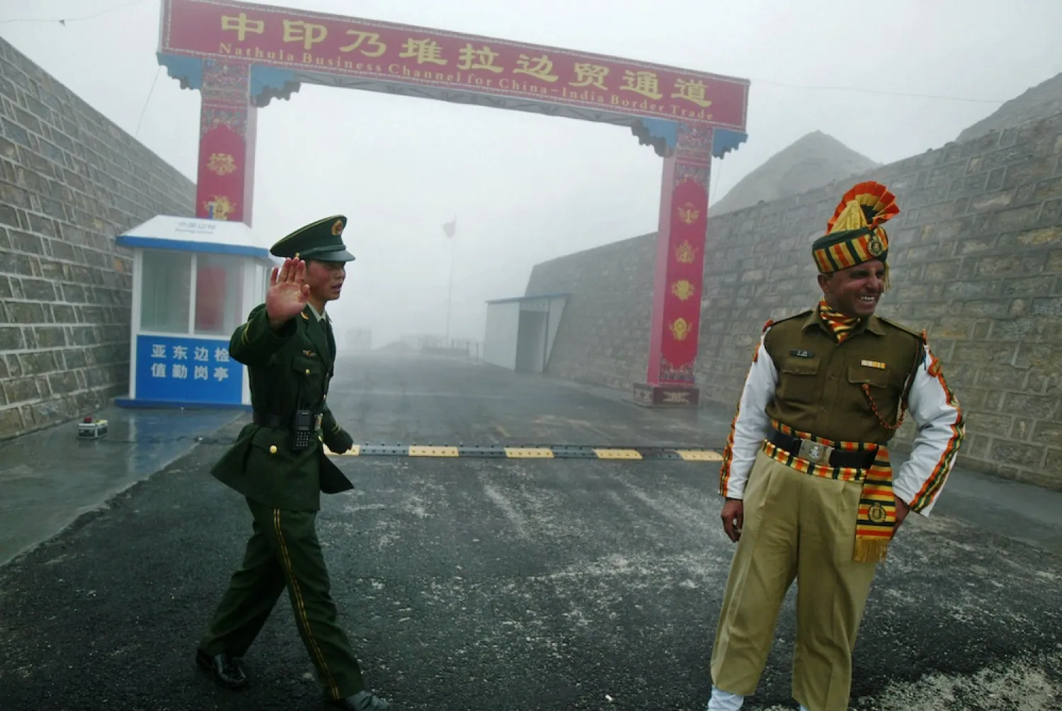 A Chinese soldier (L) and an Indian soldier (R) stand guard at the Chinese side of the ancient Nathu La border crossing between India and China. (AFP)