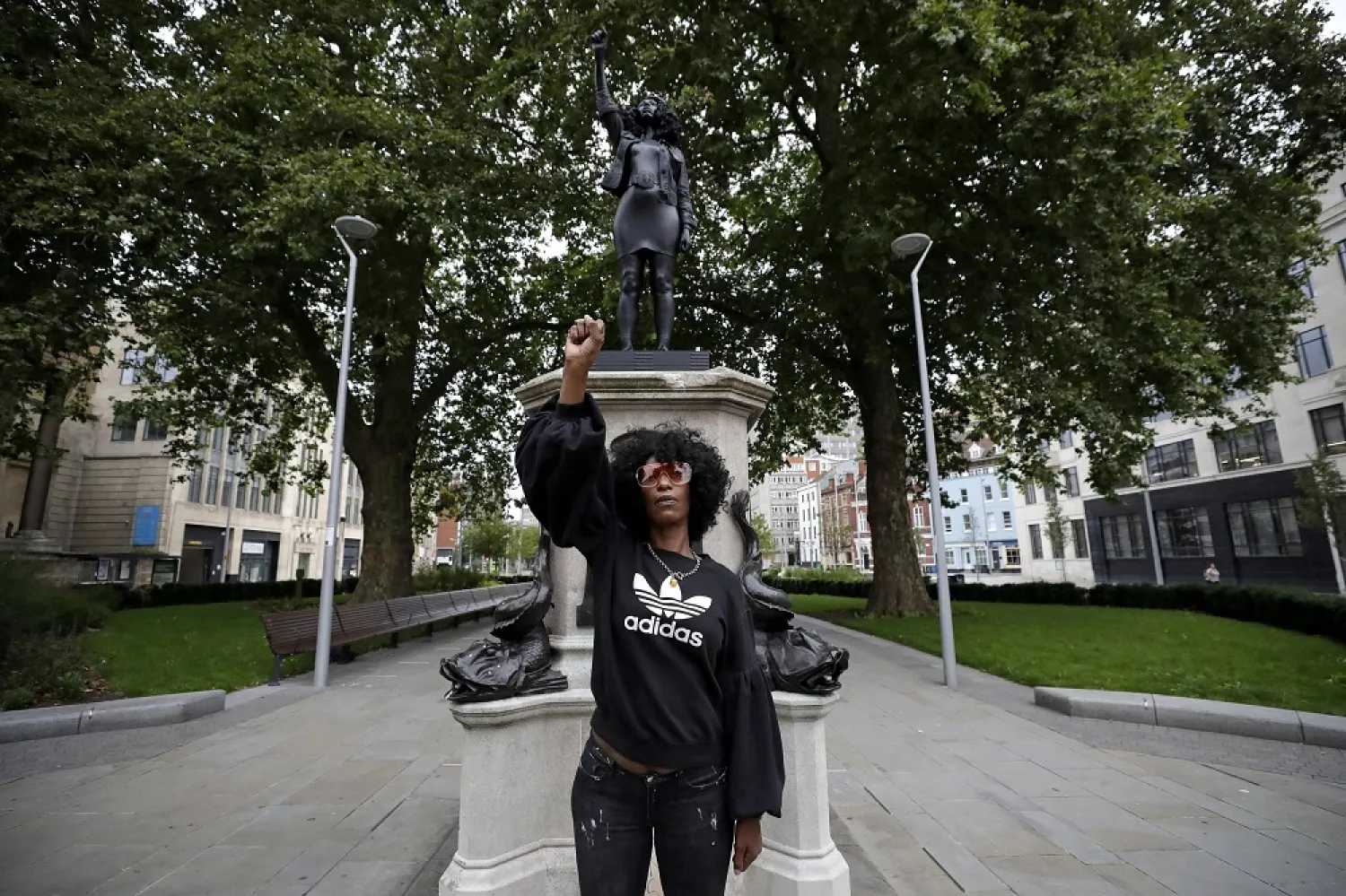 Jen Reid poses for photographs in front of the new black resin and steel statue portraying her in Bristol, England, Wednesday, July 15, 2020. (AP)