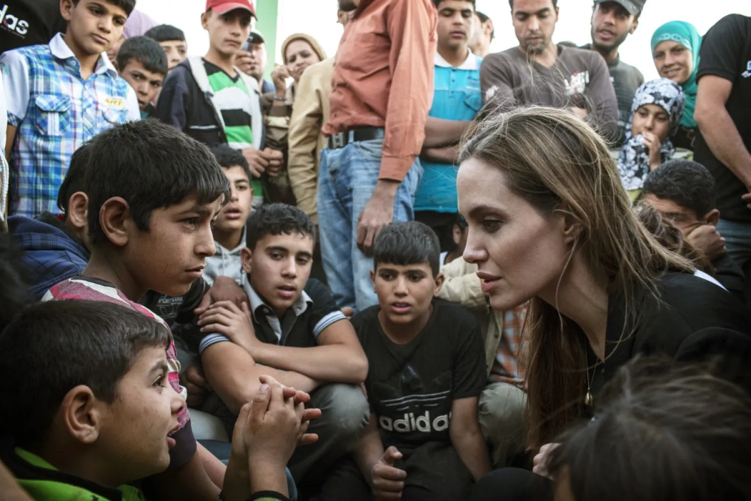 This June 18, 2013, photo released by the United Nations High Commissioner for Refugees (UNHCR) shows special envoy Angelina Jolie, right, speaking with Syrian refugees in a Jordanian military camp based near the Syria-Jordan border. (Photo credit: AP photo by United Nations High Commissioner for Refugees , O. Laban-Matte)