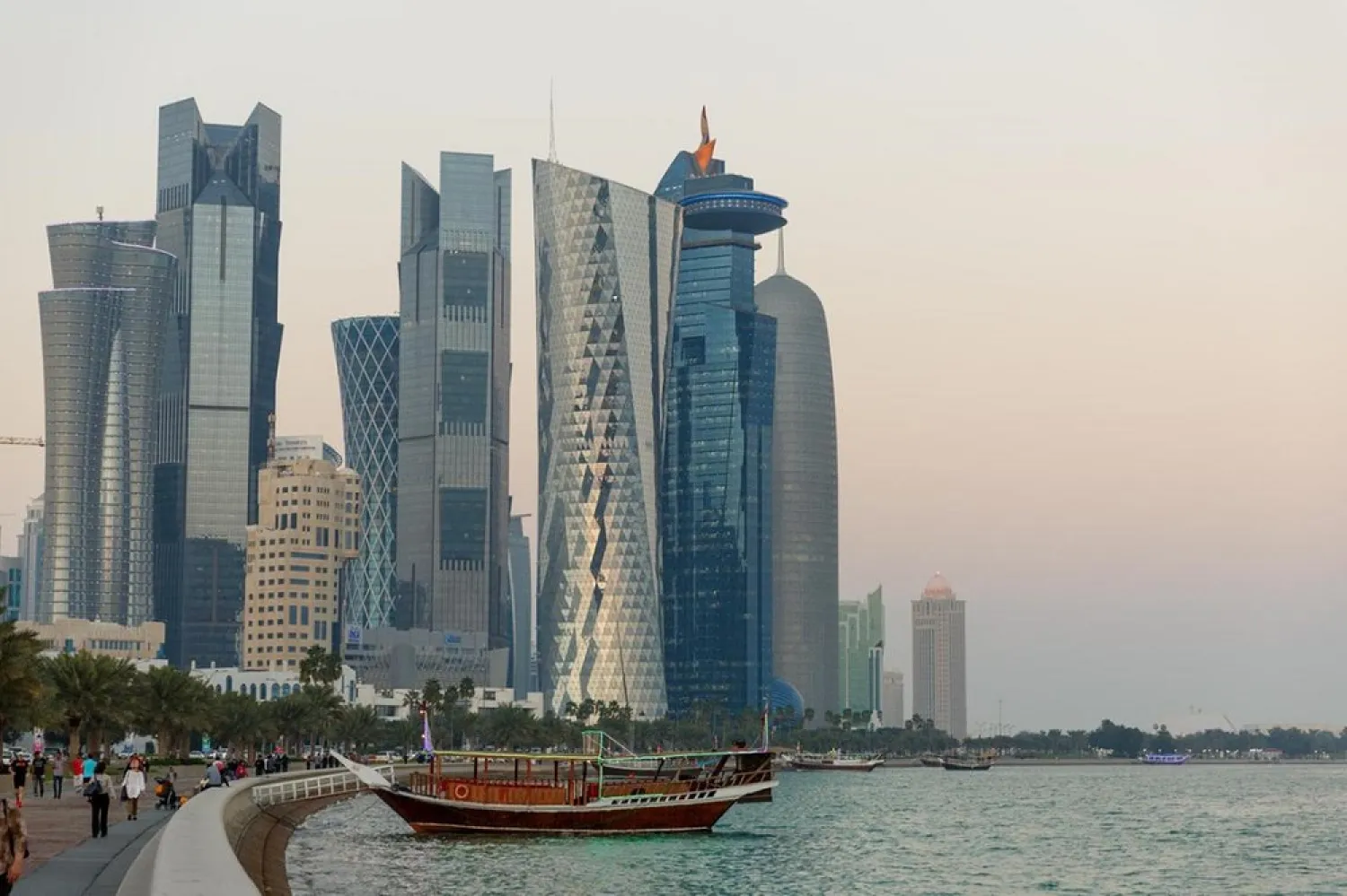 Residents walk along Doha's Corniche beneath the city's skyscrapers. (Getty Images)