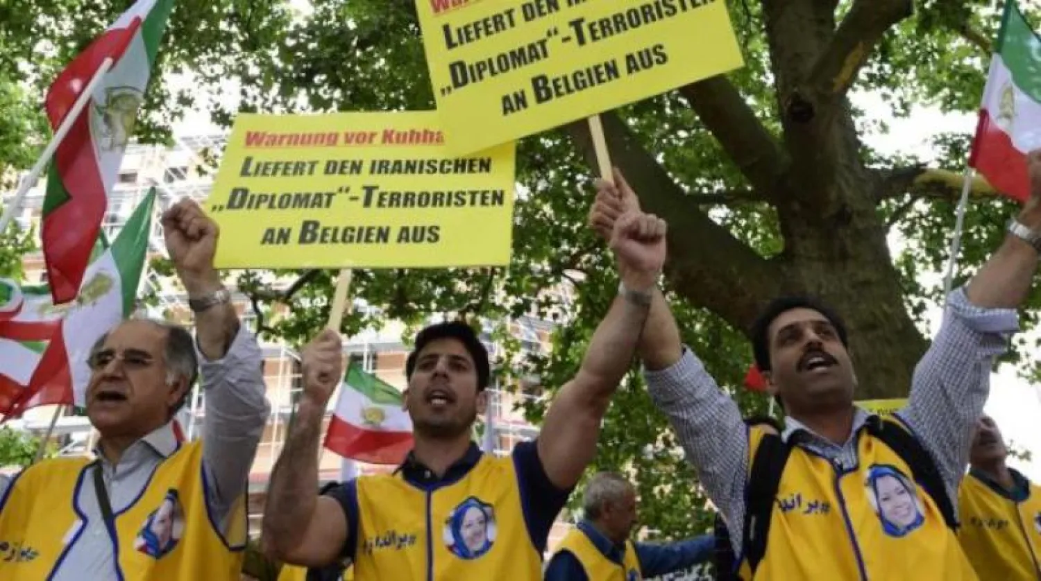 مجموعة من المتظاهرين يحملون لافتات كتب عليها «تسليم الدبلوماسي الإيراني - الإرهابي إلى بلجيكا» خلال مظاهرة ببرلين (أرشيفية - أ.ف.ب)