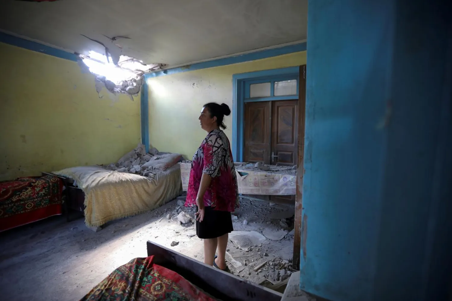 A woman stays in a house, which locals said was damaged during a recent shelling by Armenia's forces, in armed clashes on the border between Azerbaijan and Armenia, in the village of Dondar Quschi, Azerbaijan July 15, 2020. REUTERS/Aziz Karimov