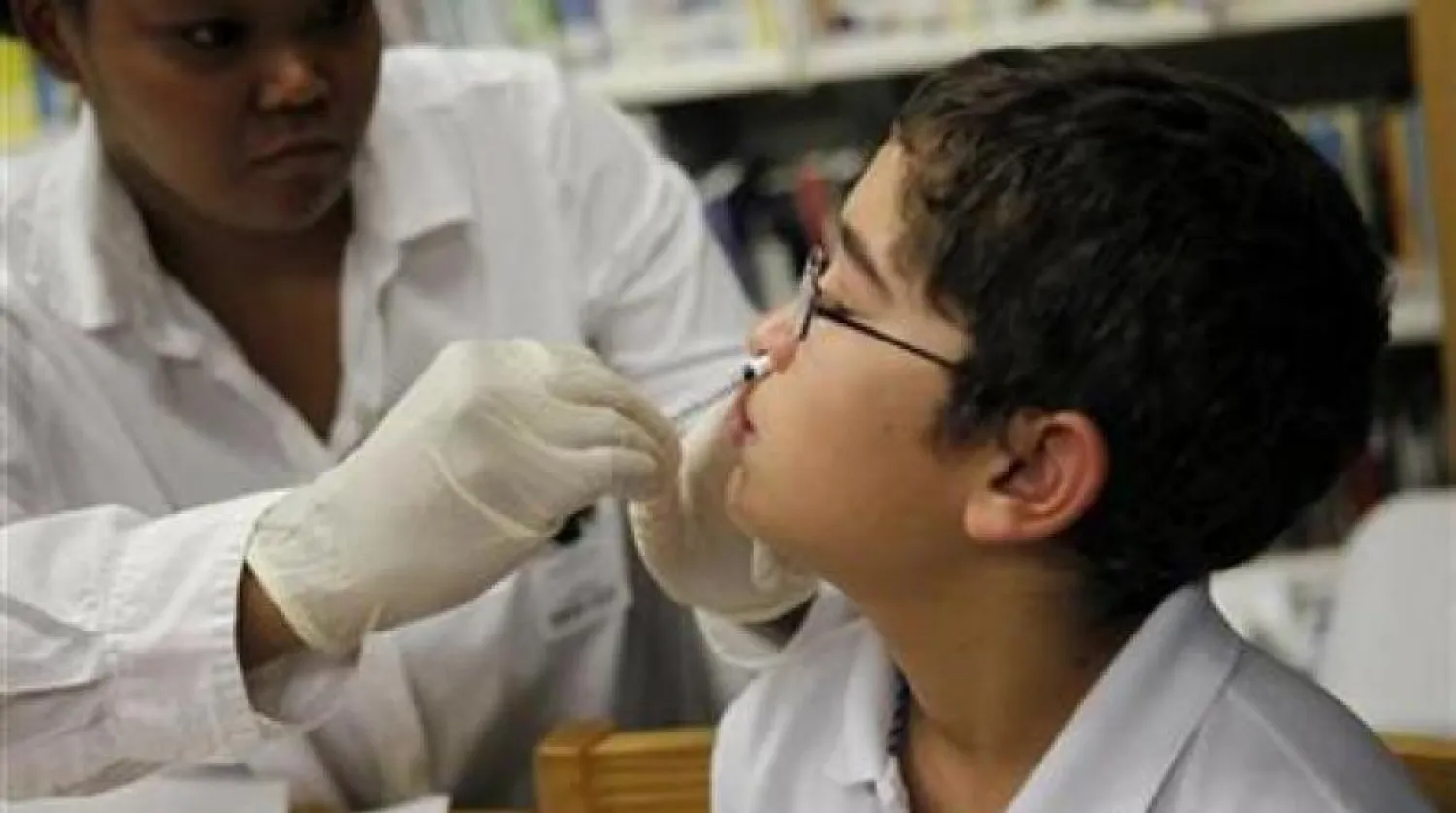 Bir çocuğa burundan aşı yapan bir doktor (Arşiv-Reuters)