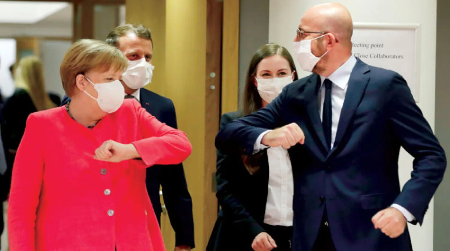 ميركل تحيّي شارل ميشال باحترام قواعد التباعد الاجتماعي أمس (أ.ف.ب)