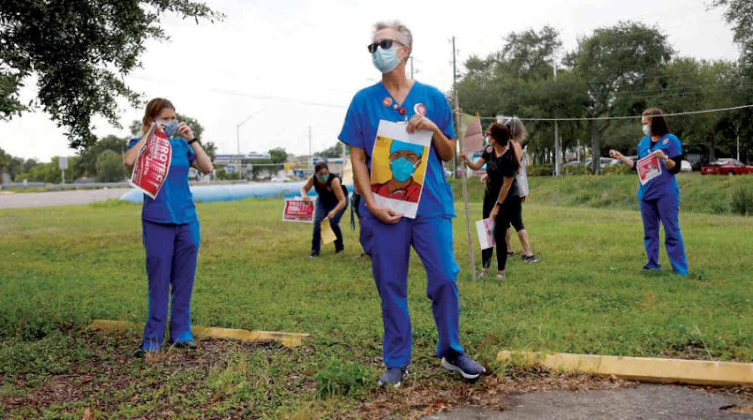 ممرضات يتظاهرن لتوعية السكان بإجراءات الوقاية من الفيروس بمستشفى في فلوريدا (رويترز)