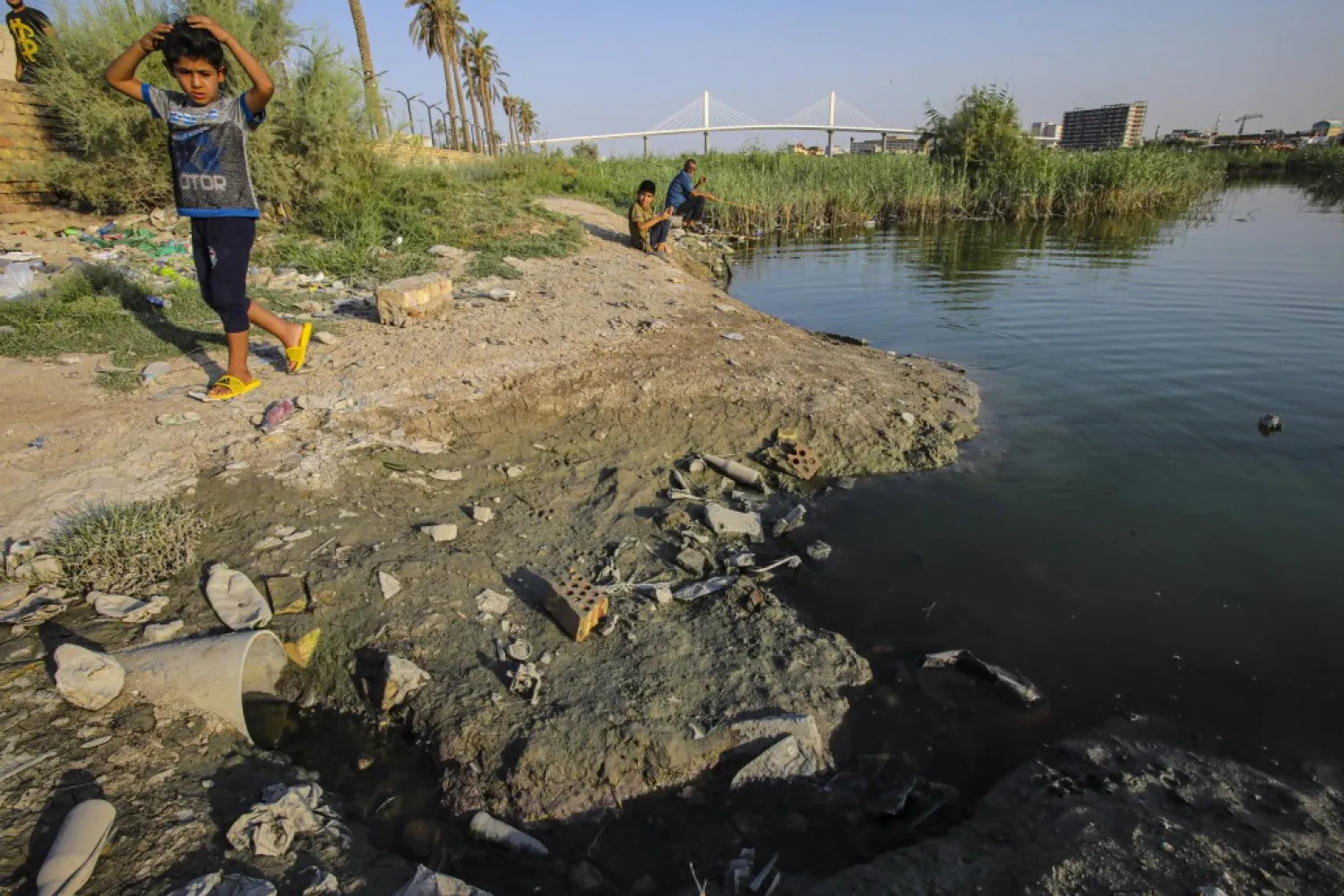 A child walks on the bank of the Shatt al-Arab waterway in Basra, Iraq on July 13, 2020. (AP)
