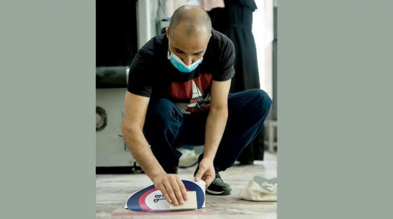 An employee at a government agency placing social distancing signs on the floor. UNICEF