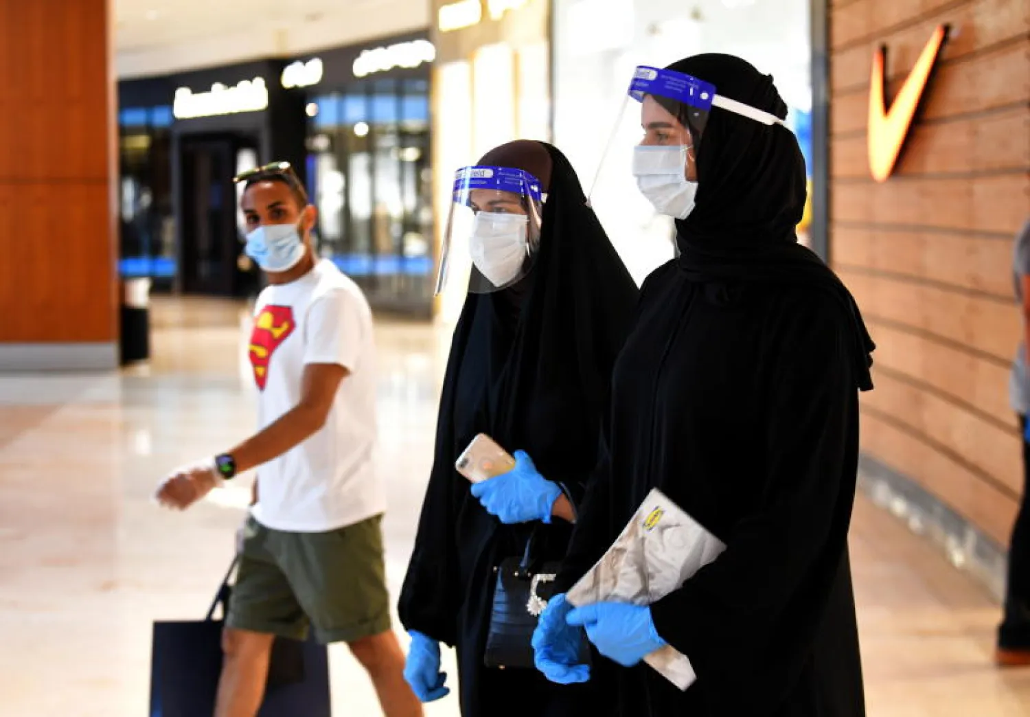 أشخاص يرتدون أقنعة واقية في مركز تسوق بمدينة الكويت (إ.ب.أ)