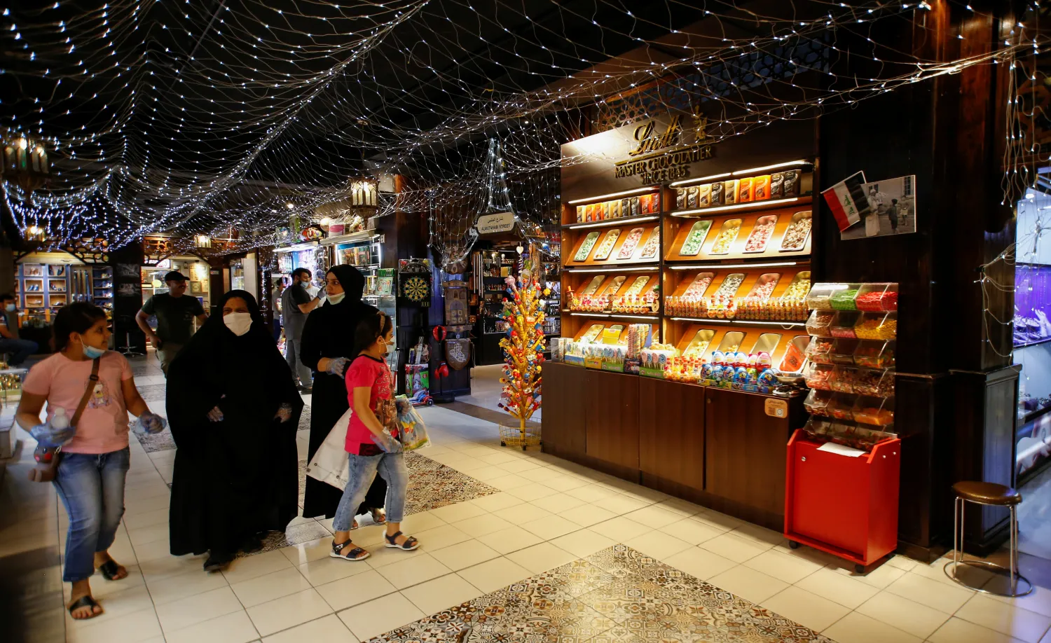 عراقيون يرتدون أقنعة في أحد أسواق بغداد (رويترز)