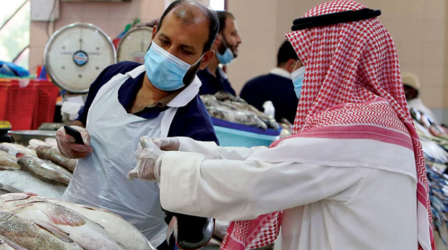 متسوق يشتري أسماكاً في مدينة الكويت (أ.ف.ب)