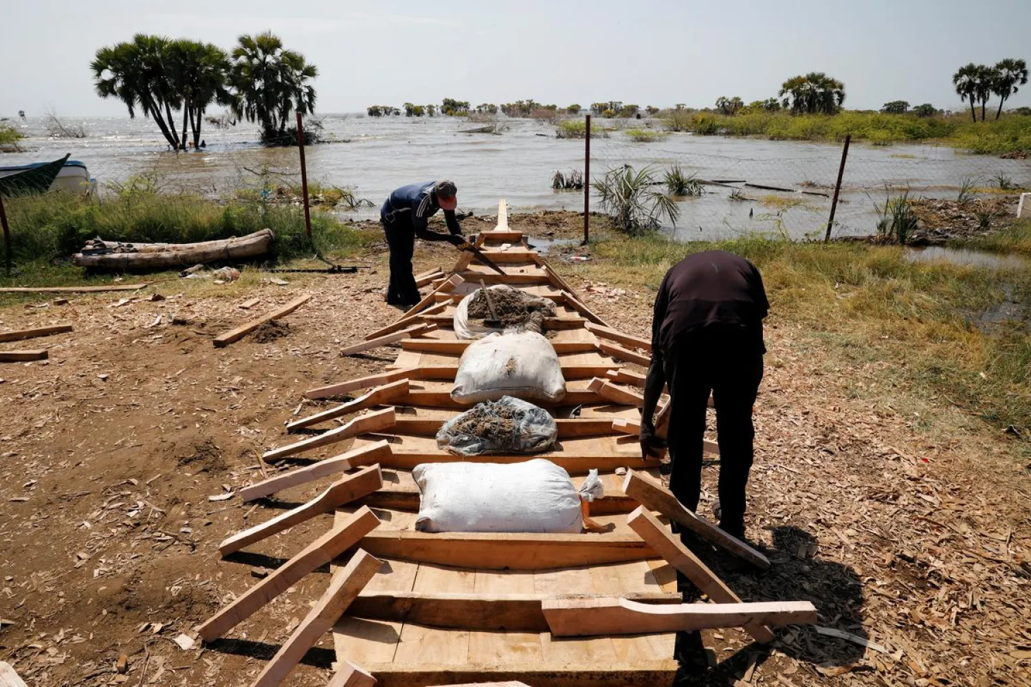 Men construct a fishing boat on a beach at Lake Turkana, near the town of Kalokol, Turkana county, Kenya, July 4, 2020. (Reuters)