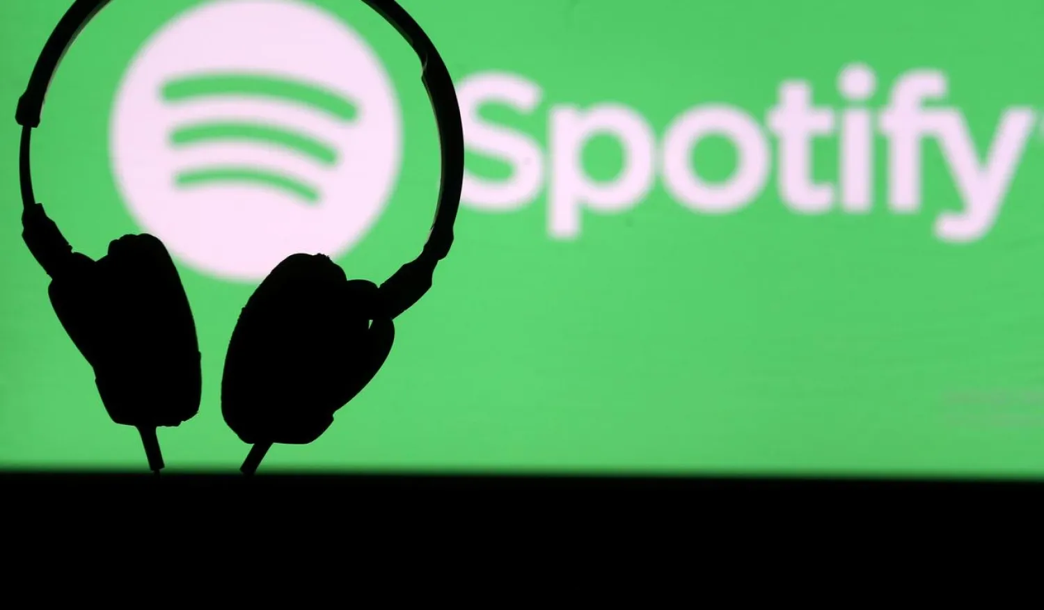 A headset in front of a screen projection of Spotify logo, in this picture taken April 1, 2018. (Reuters)