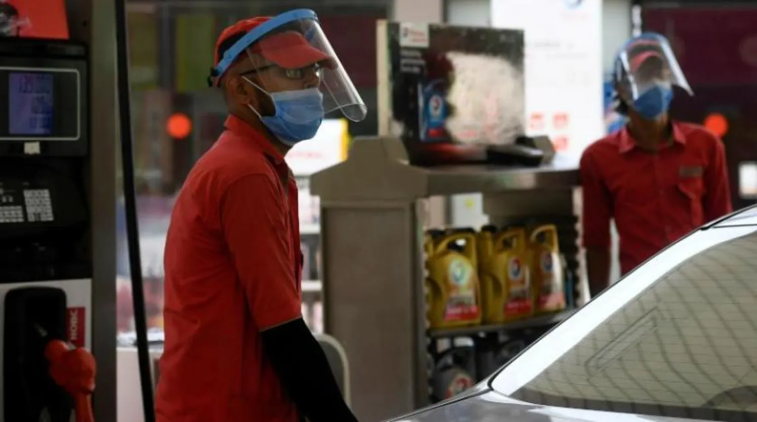 یک کارگر پاکستانی شاغل در یک پمپ بنزین در حالی که ماسک بر صورت دارد (فرانس پرس)
