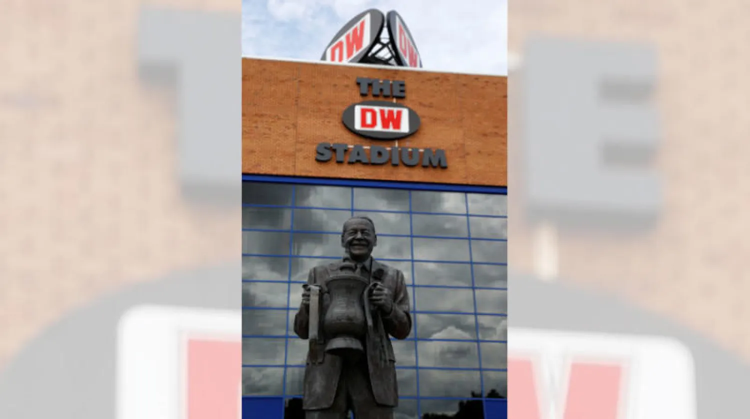 تمثال ديف ويلان رئيس ويغان السابق حاملاً كأس إنجلترا في أبرز إنجاز للنادي الذي يعاني الإفلاس (رويترز)