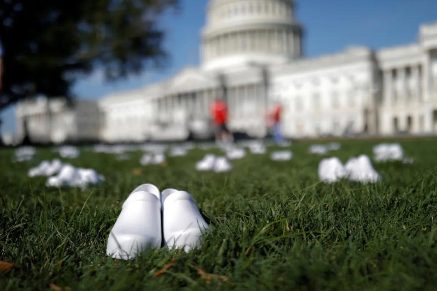 أحذية الممرضات البلاستيكية البيضاء على المساحة العشبية أمام مبنى الكابيتول (رويترز)