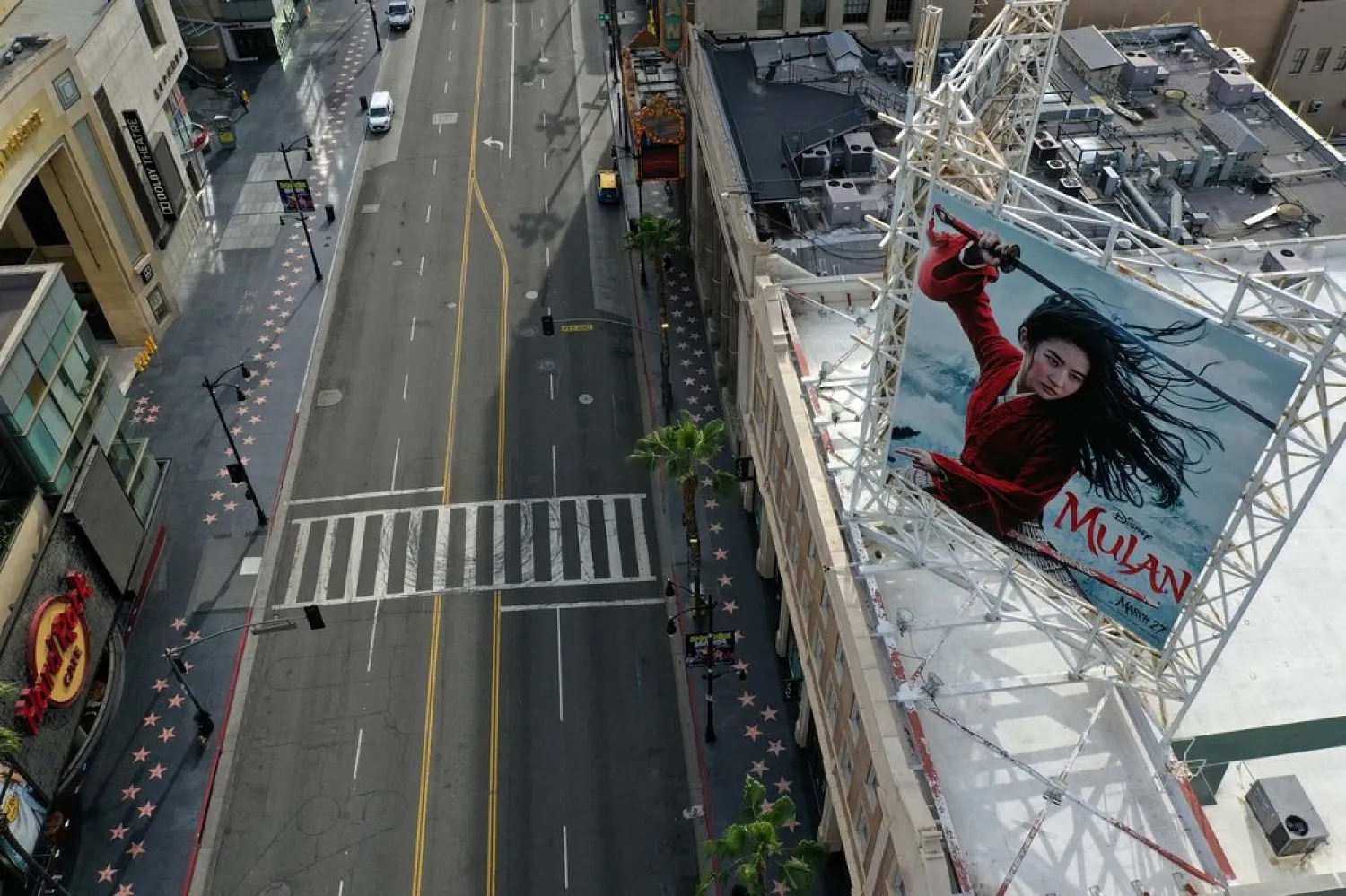 A poster of the Walt Disney Studios' ‘Mulan’ movie towers over an empty Hollywood Boulevard during the global coronavirus outbreak, in Hollywood, Los Angeles, California, US, March 31, 2020. (Reuters)