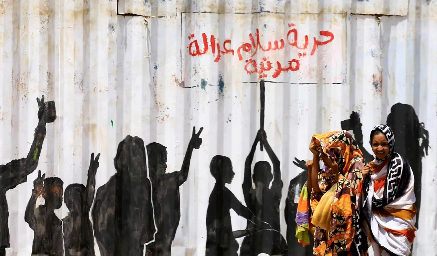 Civilians walk past graffiti reading in Arabic 'Freedom, Peace, Justice and Civilian' in the Burri district of Khartoum, Khartoum, Sudan, July 10, 2019. (Reuters)