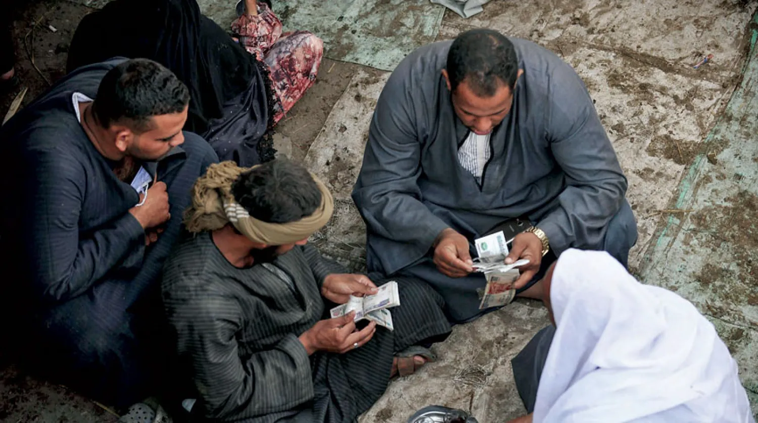 تجّار في سوق لبيع المواشي بالجيزة قرب القاهرة أول من أمس (د.ب.أ)