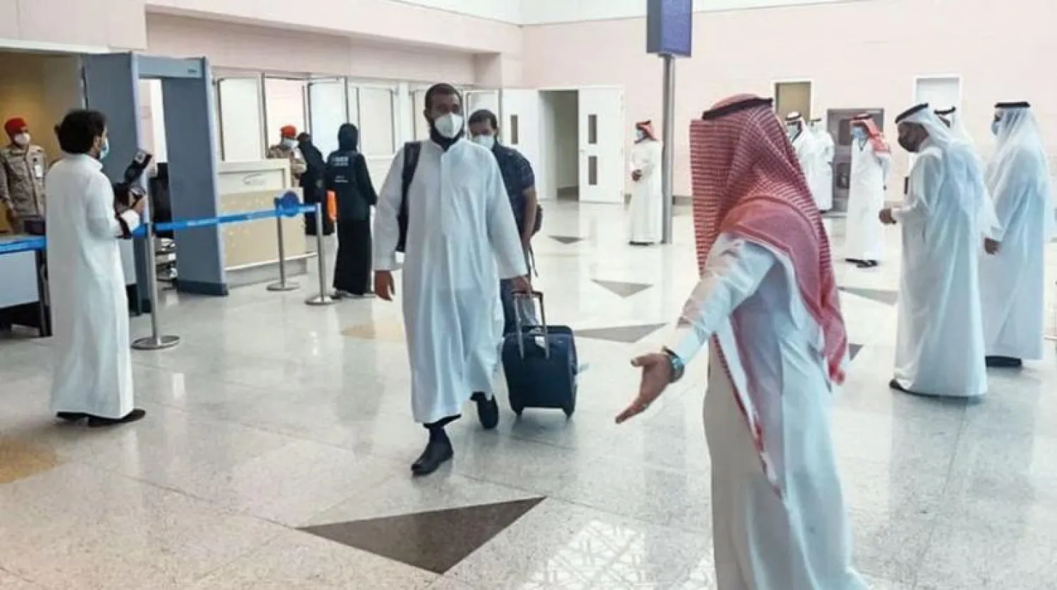Employees from the Saudi Ministry of Hajj and Umrah receive the first coming batch of pilgrims (Asharq Al-Awsat)