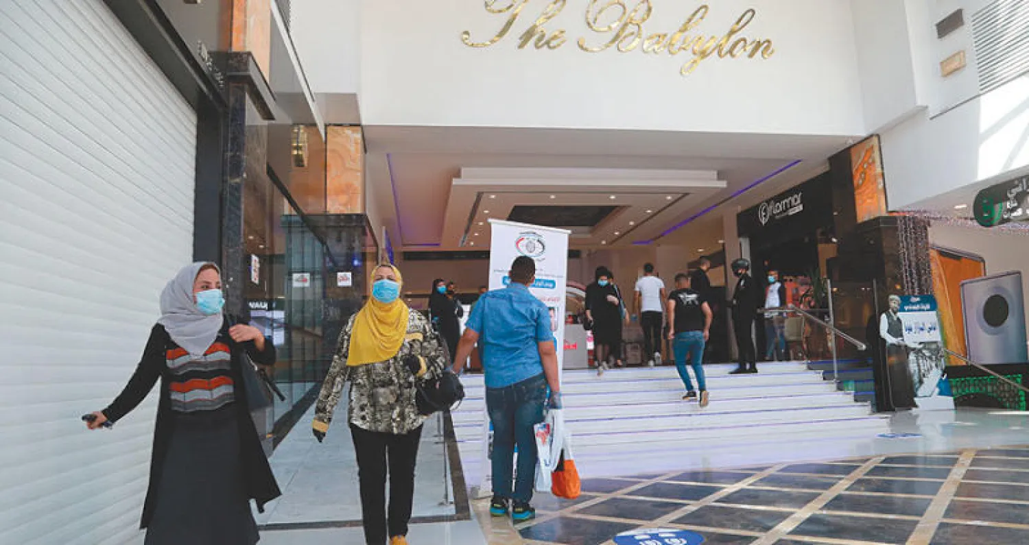 متسوقون في مركز تجاري ببغداد (أ.ب)