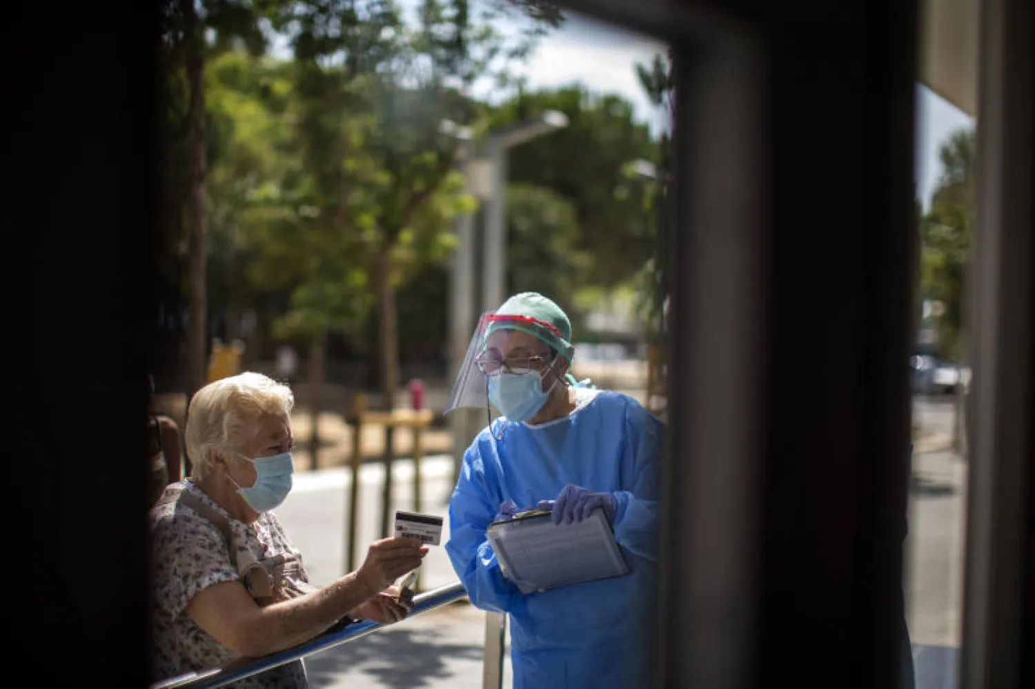عاملة بالمجال الصحي تستقبل المرضى في مستشفى على مشارف برشلونة (أ.ب)