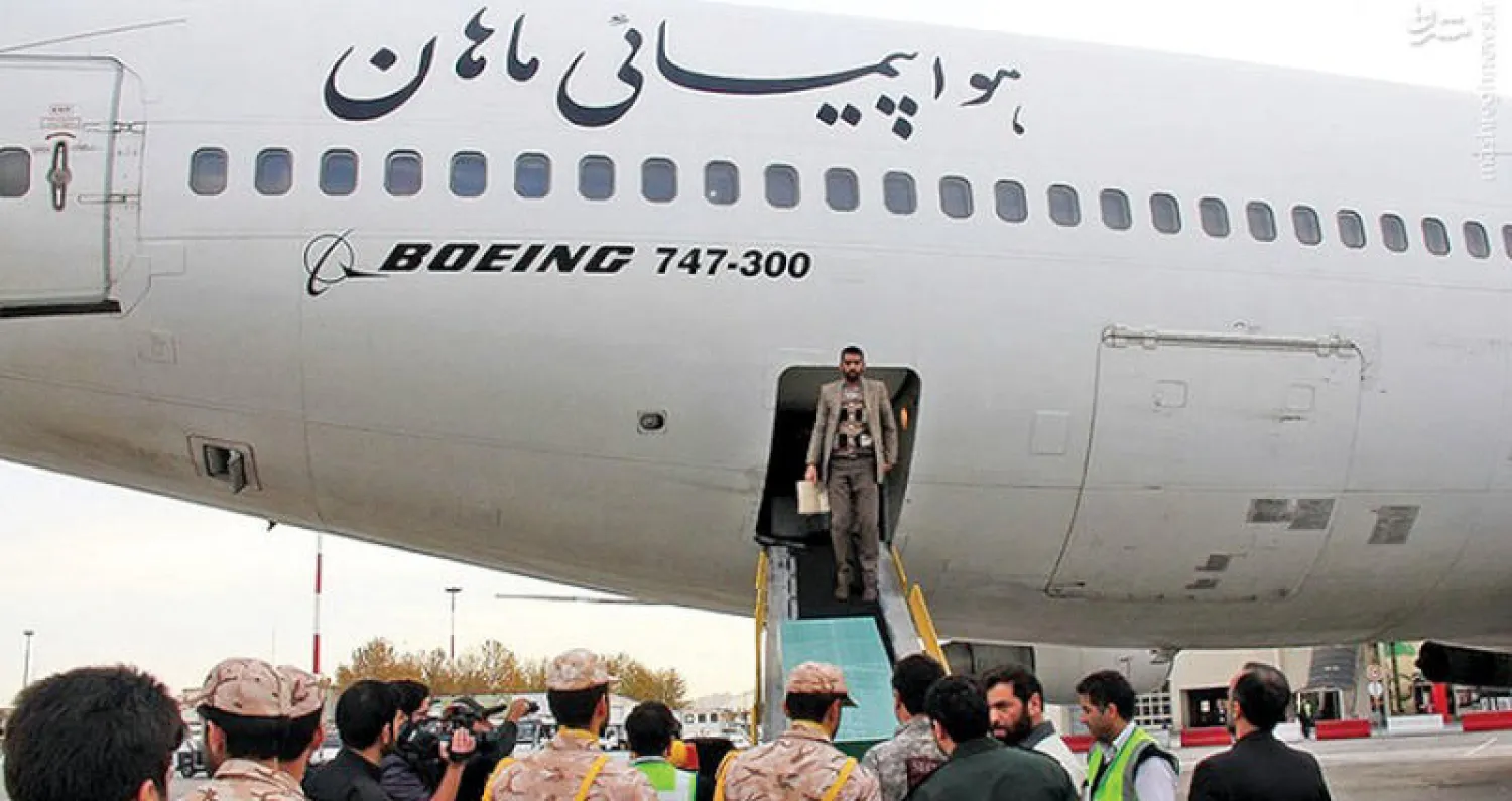 جنود يجتمعون أمام طائرة تابعة لخطوط «ماهان» نقلت جثث عناصر من «الحرس الثوري» قضوا في سوريا خلال 2016 (إرنا)