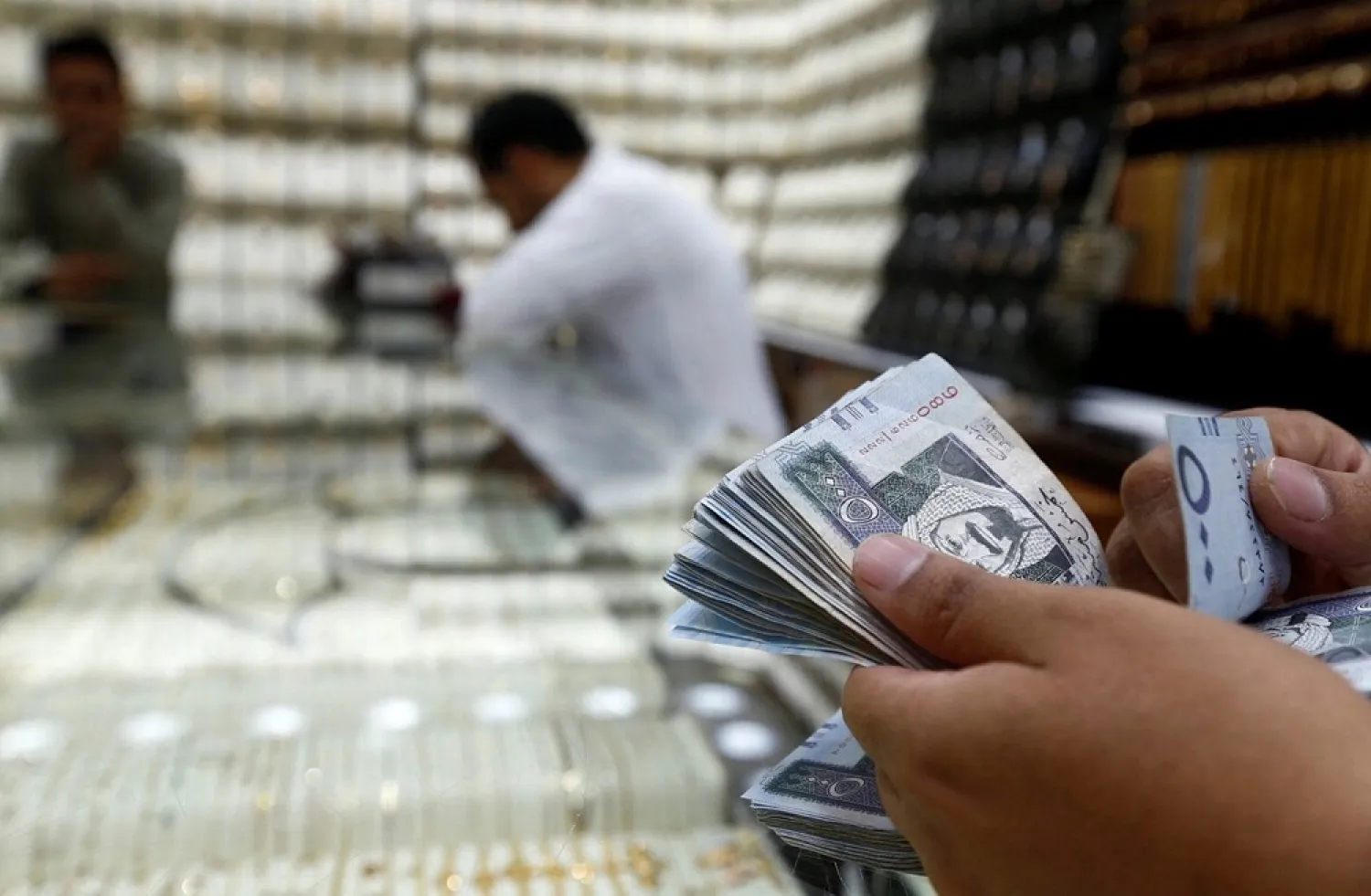 A man counts Saudi Riyal banknotes in a jewelry store story in Riyadh, Saudi Arabia, October 18, 2017. (Reuters)