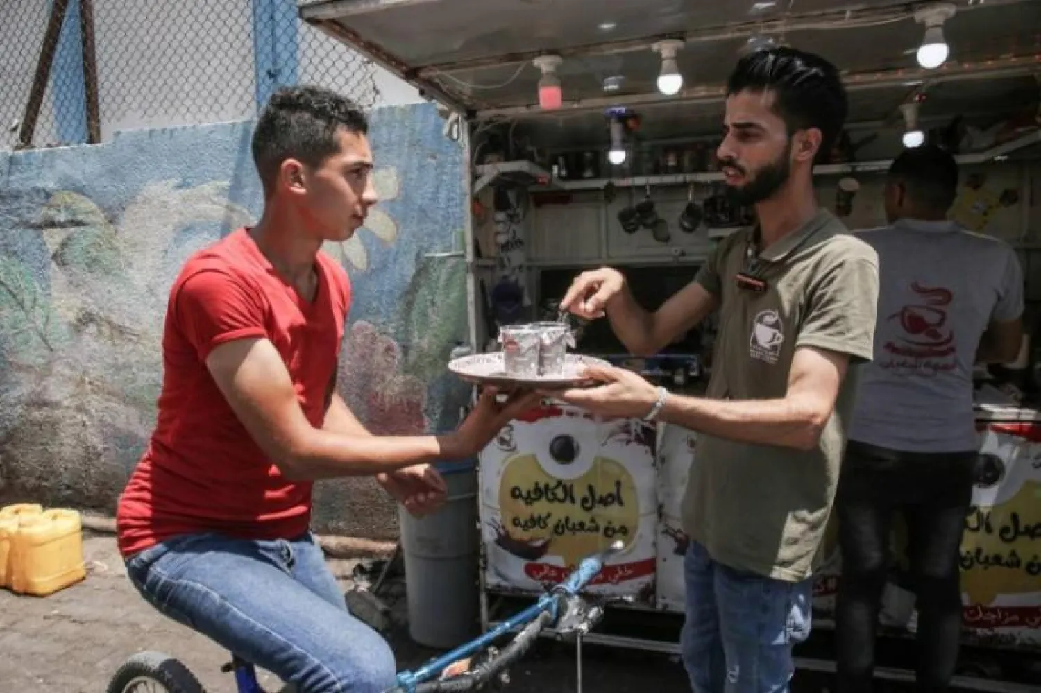 صورة لأحد العاملين في المقهى وهو يوصل طلبا لزبون (أ.ف.ب)