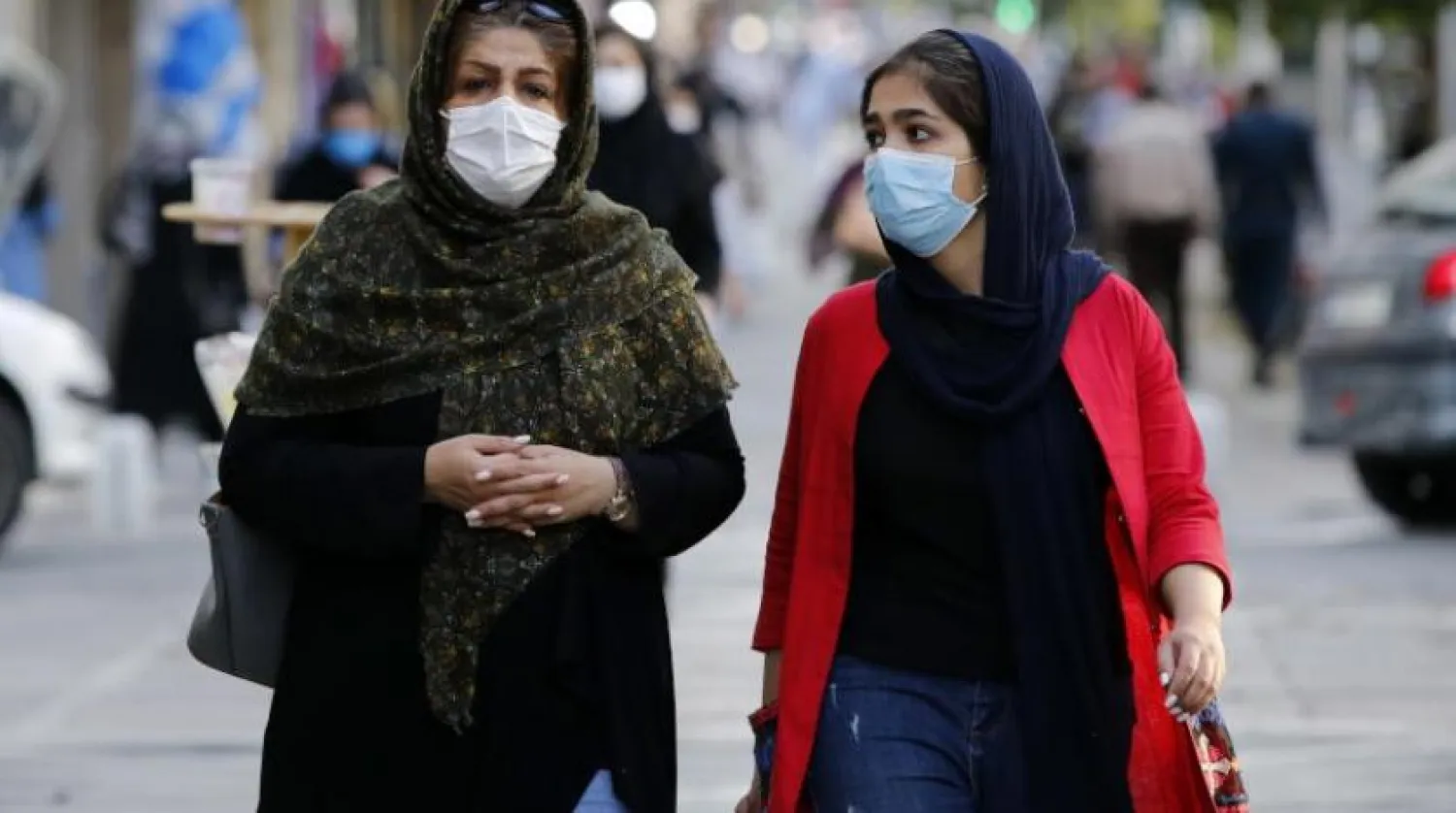 İranlı kadınlar başkent Tahran’da sokakta yürürken maske takıyor (EPA)