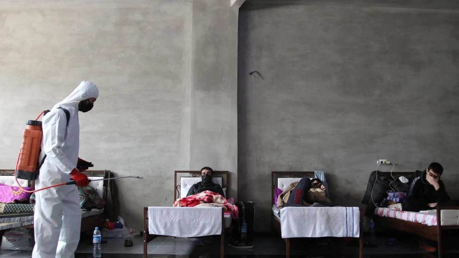 A health worker disinfects a makeshift quarantine facility near the town of Jisr al-Shughur, west of Idlib. (AFP)