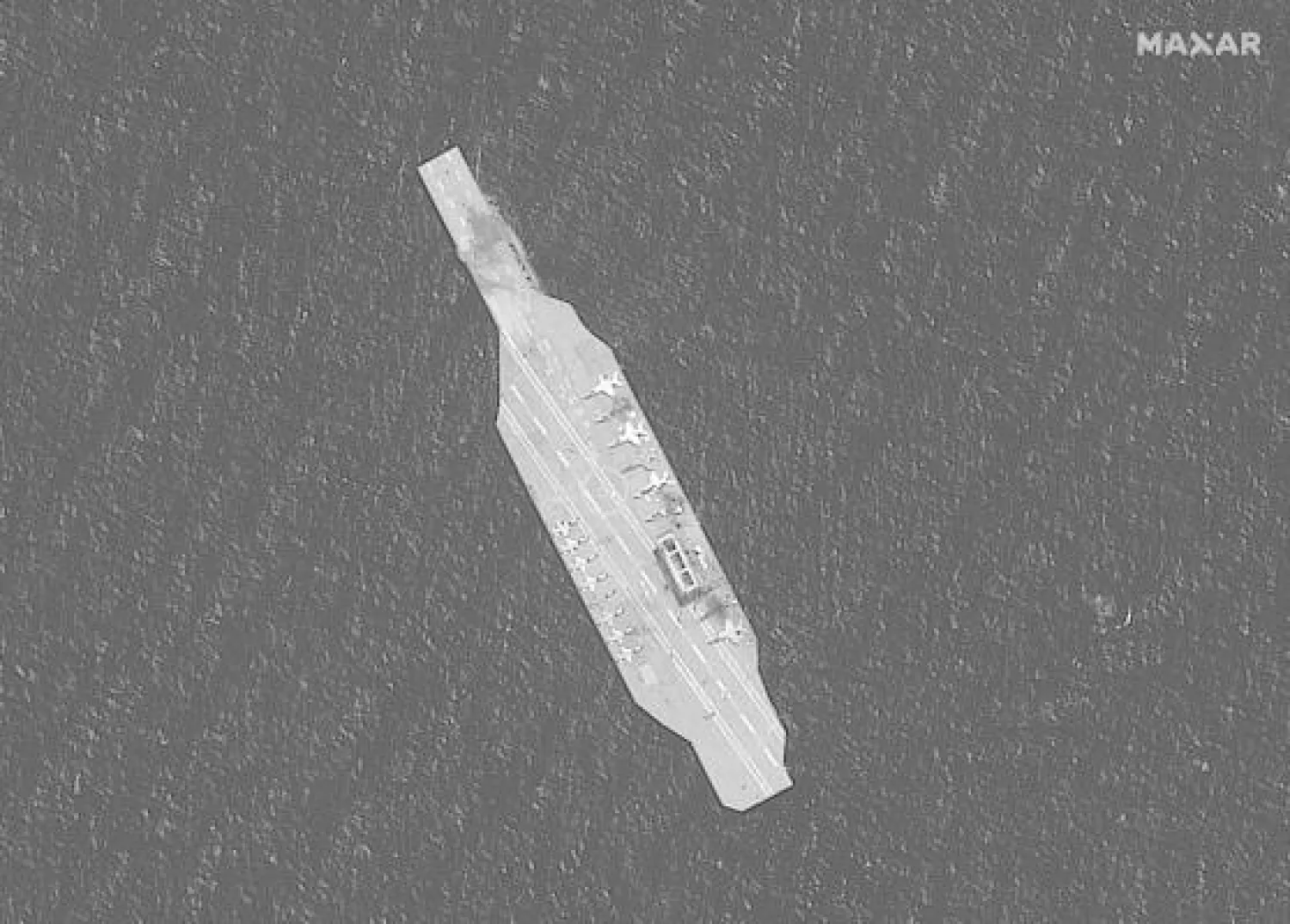 In this Tuesday, July 28, 2020, satellite photo provided by Maxar Technologies, a mockup aircraft carrier built by Iran is seen damaged in the Strait of Hormuz amid a live-fire drill conducted by Iran's Revolutionary Guard. (Maxar Technologies via AP)
