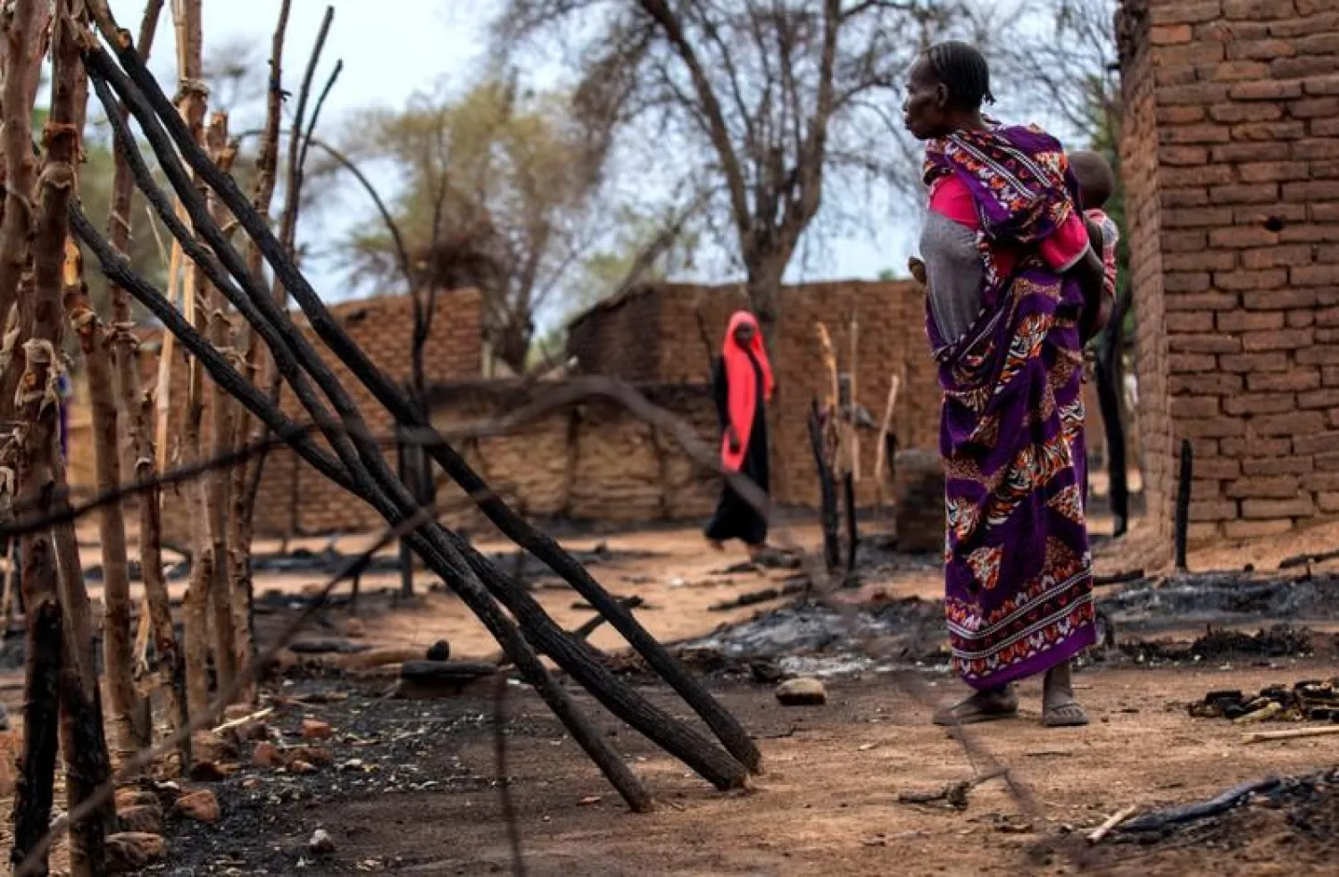 A woman looks at burnt houses during clashes between nomads and residents in Deleij village, located in Wadi Salih locality, Central Darfur, Sudan June 11, 2019. REUTERS/Stringer

