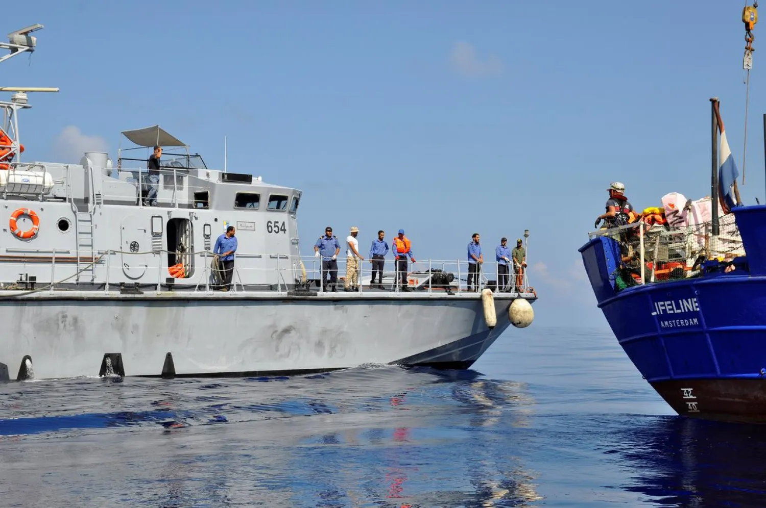 A Libyan coast guard vessel is seen next to the Mission Lifeline rescue boat in the central Mediterranean Sea, June 21, 2018. Picture taken June 21, 2018. Hermine Poschmann/ Misson-Lifeline/Handout via REUTERS