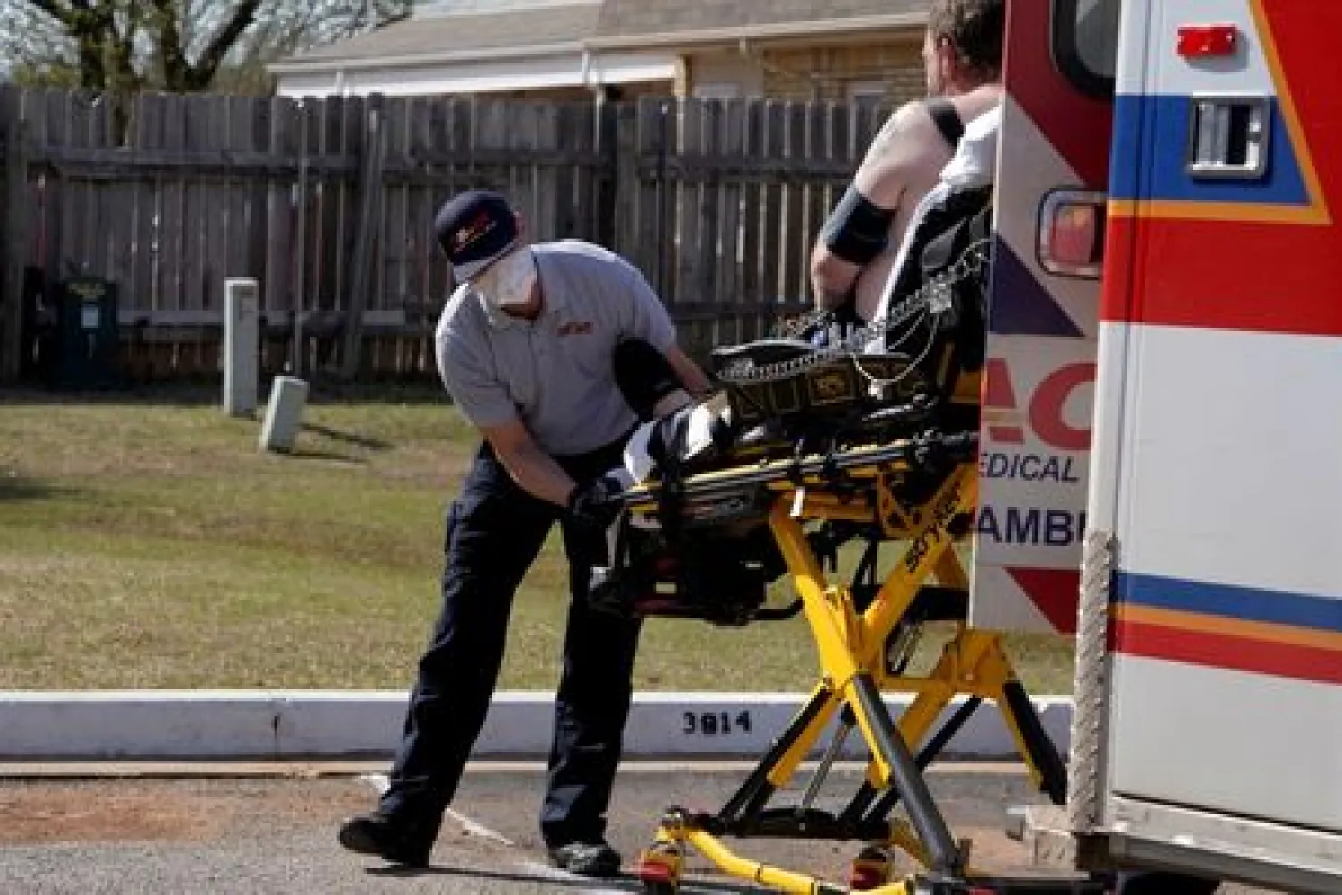 FILE PHOTO: REACT EMS paramedic Brian Myers, wearing a protective mask and gloves, loads up a potential coronavirus disease (COVID-19) patient for transport in Shawnee, Oklahoma, U.S. March 26, 2020. REUTERS/Nick Oxford
